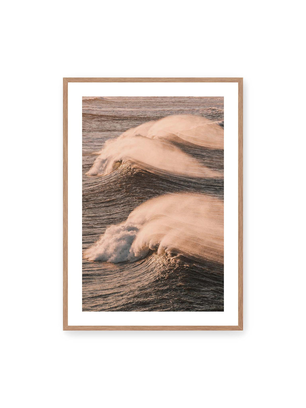 70x100 cm, weißer Galerie-Rand, Eichenrahmen – Zwei brechende Wellen mit verwehter Gischt im warmen Licht über einer dunklen, strukturierten Wasserfläche.