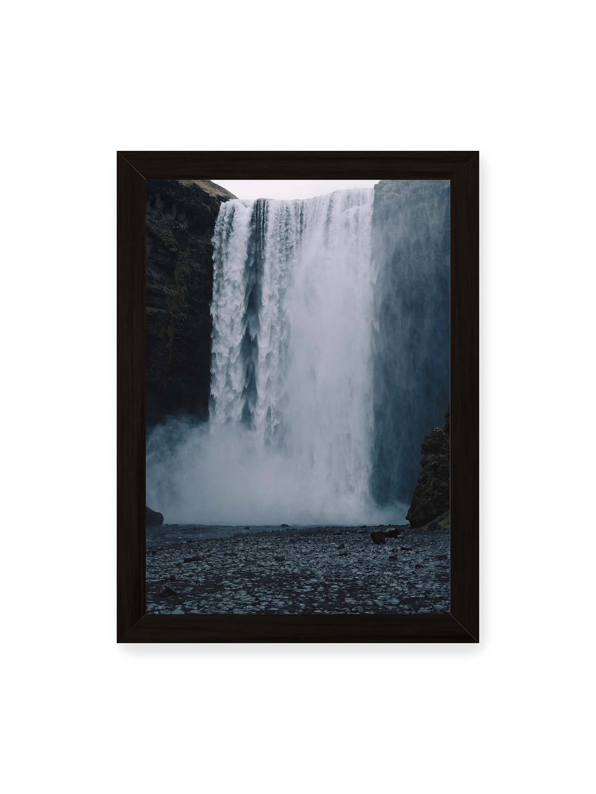 21x30 cm, schwarzer Rahmen – Mächtiger Wasserfall zwischen dunklen Felswänden mit dichtem Sprühnebel und steinigem Vordergrund.