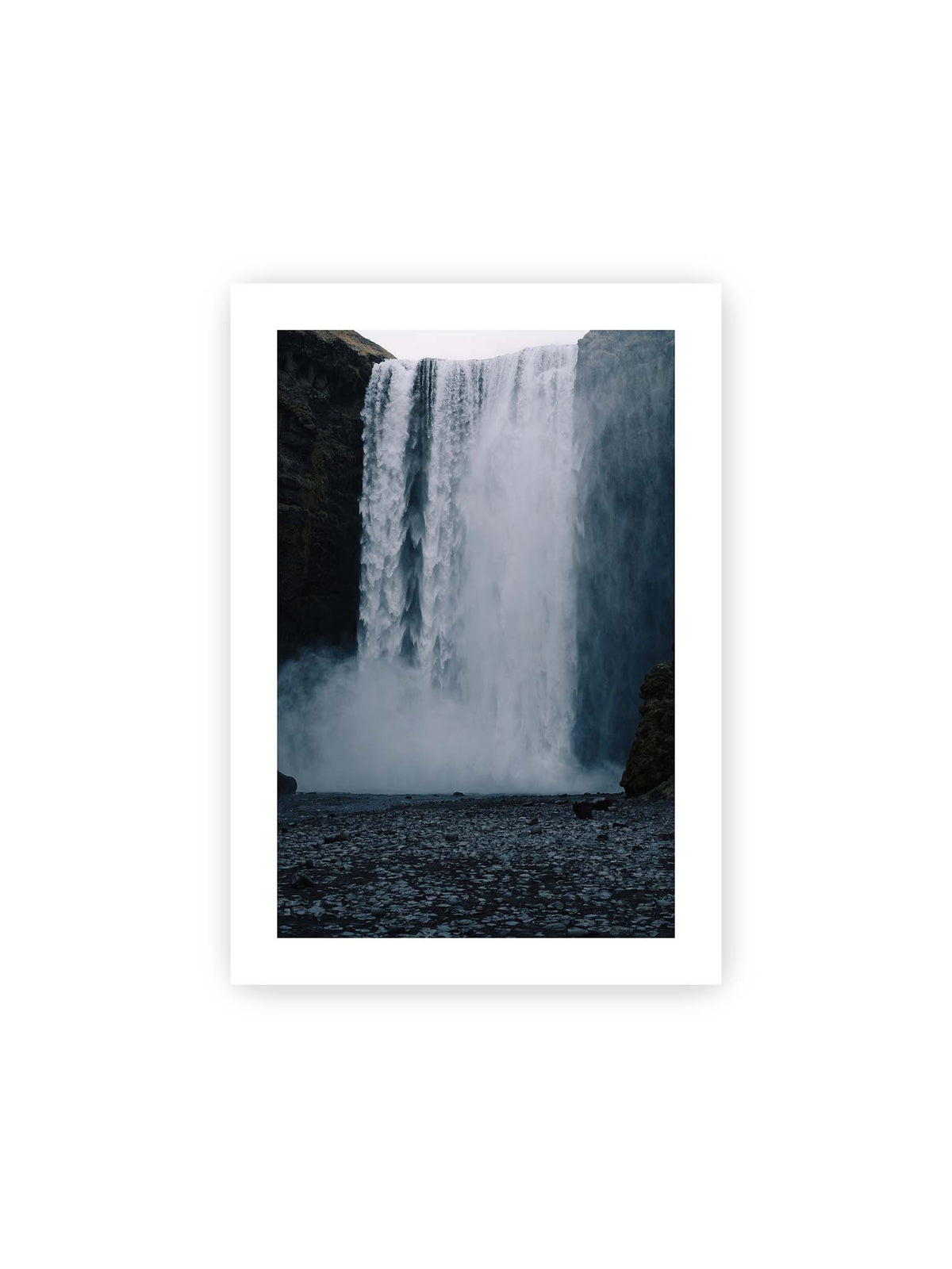 21x30 cm, weißer Galerie-Rand – Mächtiger Wasserfall zwischen dunklen Felswänden mit dichtem Sprühnebel und steinigem Vordergrund.