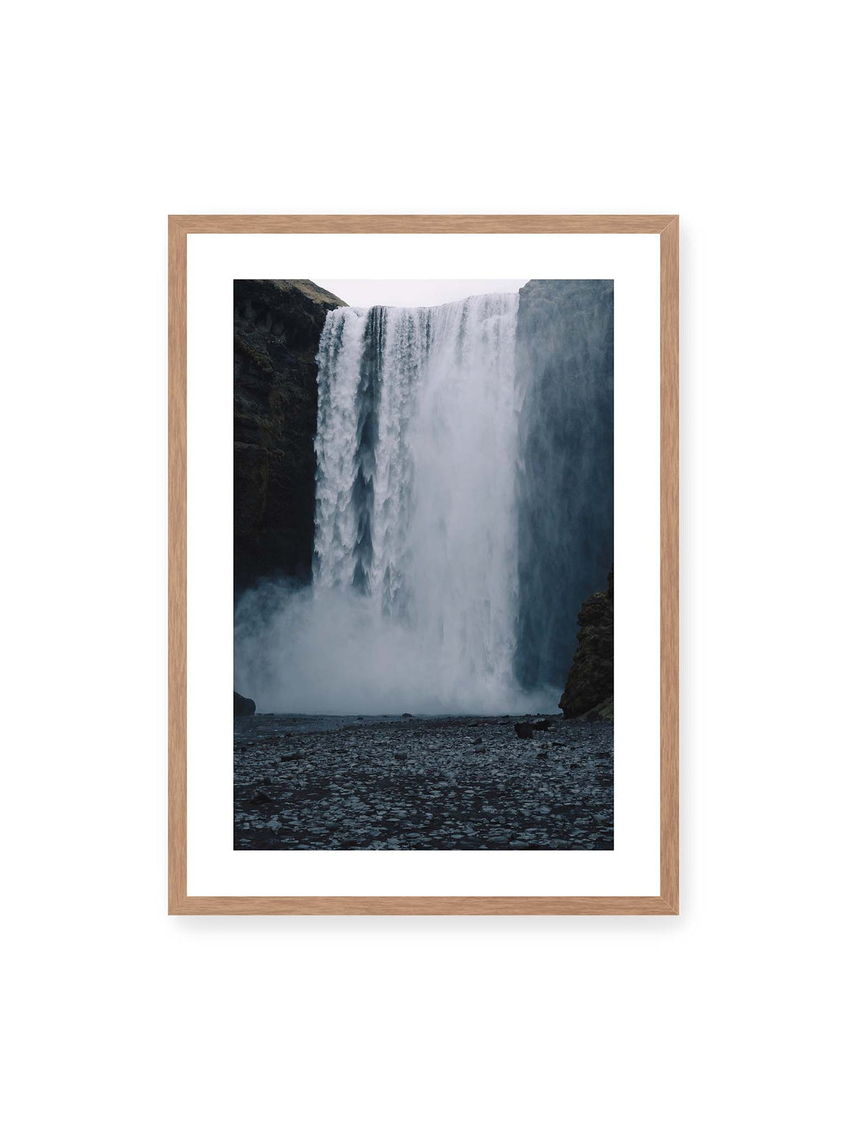 50x70 cm, weißer Galerie-Rand, Eichenrahmen – Mächtiger Wasserfall zwischen dunklen Felswänden mit dichtem Sprühnebel und steinigem Vordergrund.