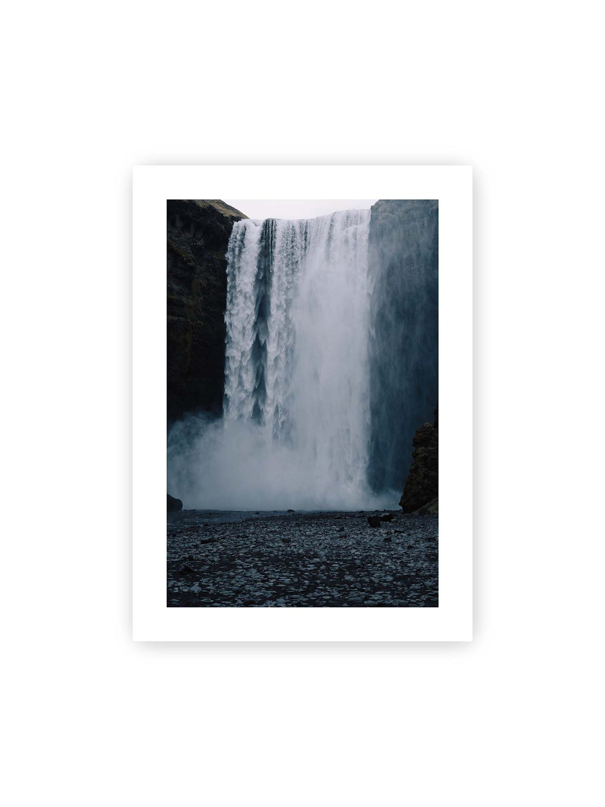 50x70 cm, weißer Galerie-Rand – Mächtiger Wasserfall zwischen dunklen Felswänden mit dichtem Sprühnebel und steinigem Vordergrund.