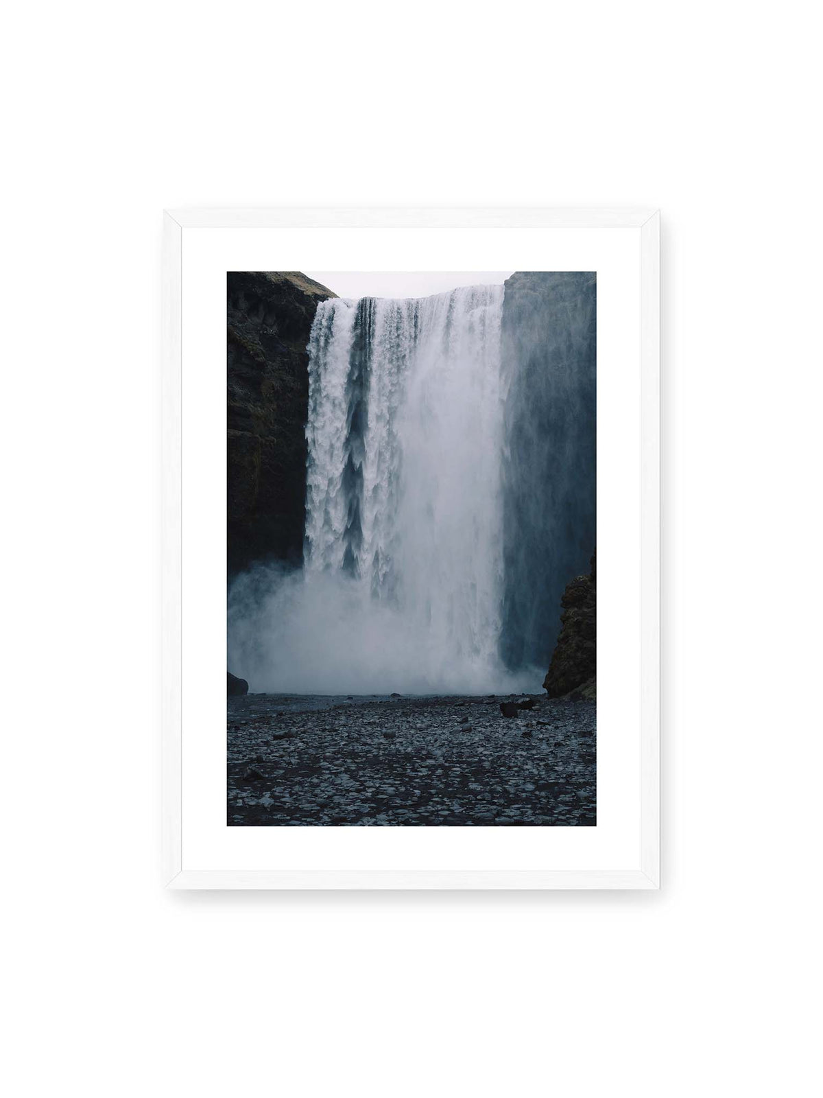 50x70 cm, weißer Galerie-Rand, weißer Rahmen – Mächtiger Wasserfall zwischen dunklen Felswänden mit dichtem Sprühnebel und steinigem Vordergrund.