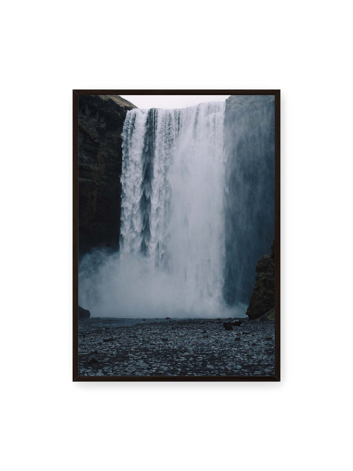 70x100 cm, schwarzer Rahmen – Mächtiger Wasserfall zwischen dunklen Felswänden mit dichtem Sprühnebel und steinigem Vordergrund.
