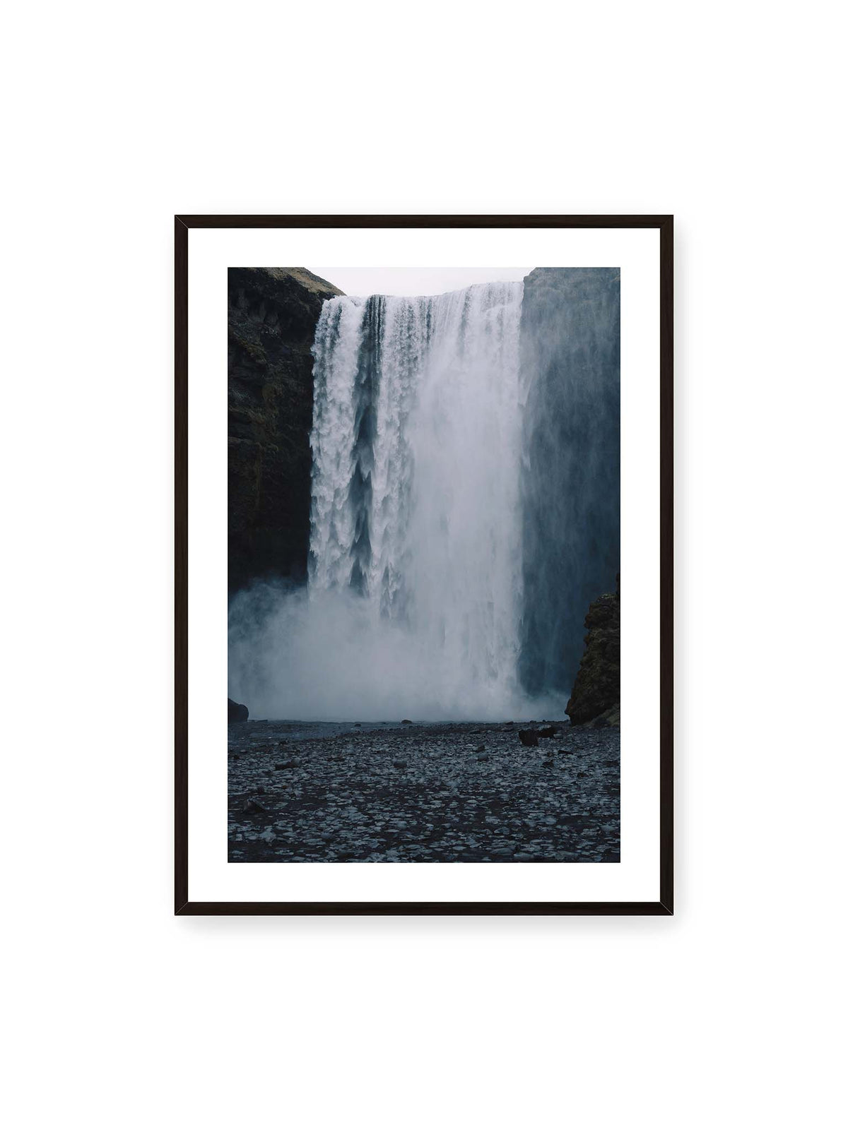 70x100 cm, weißer Galerie-Rand, schwarzer Rahmen – Mächtiger Wasserfall zwischen dunklen Felswänden mit dichtem Sprühnebel und steinigem Vordergrund.