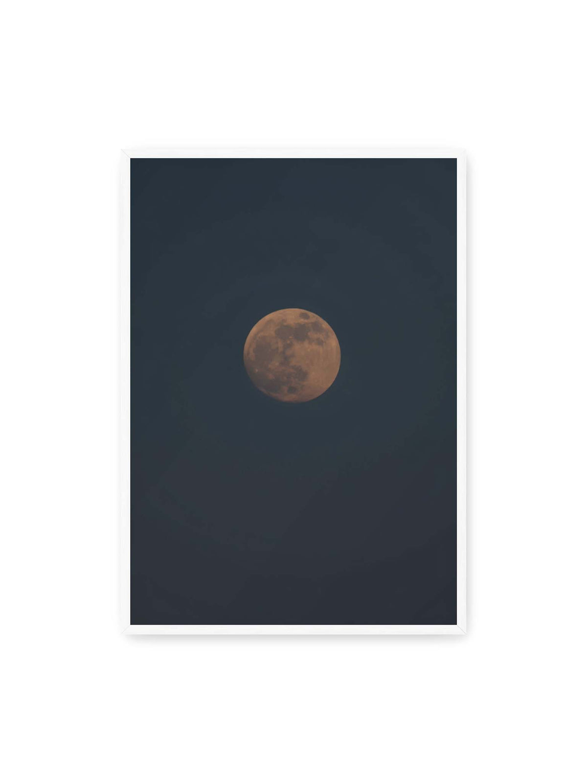 70x100 cm, weißer Rahmen – Kupferfarbener Mond vor einem weitläufigen dunkelblauen Himmel mit deutlich sichtbaren Oberflächenstrukturen.