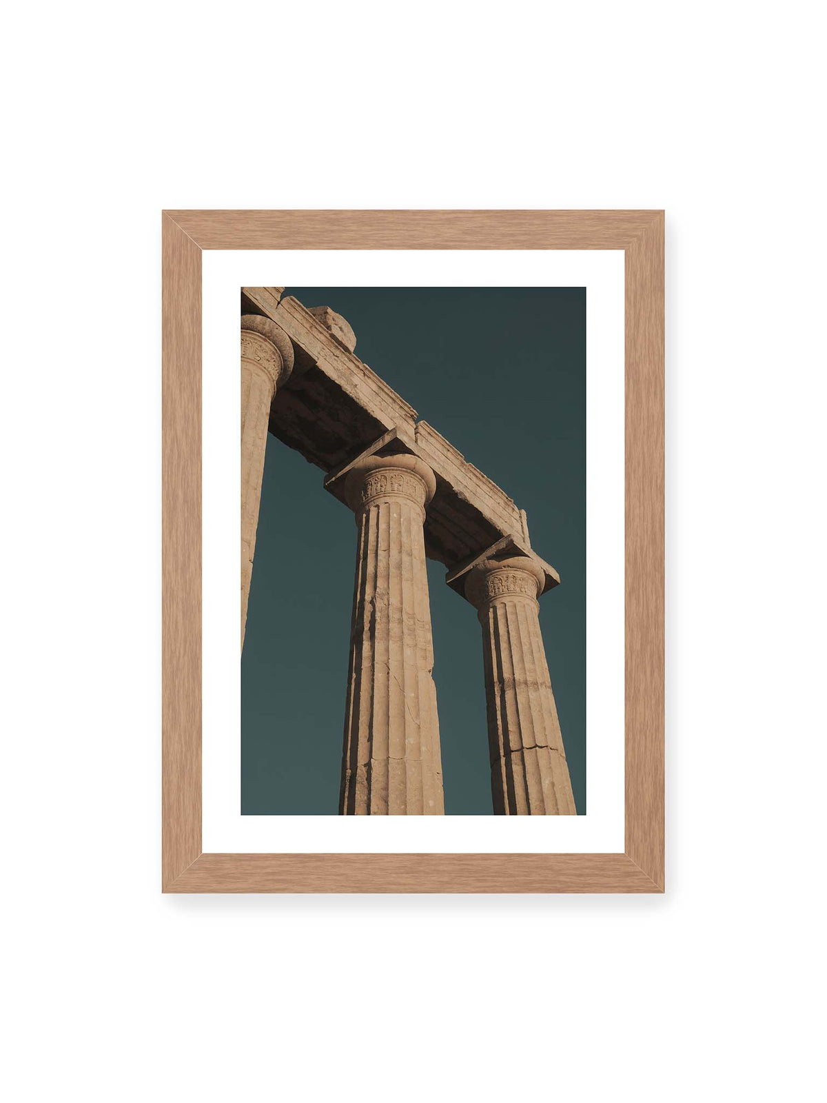 21x30 cm, weißer Galerie-Rand, Eichenrahmen – Monumentale Steinsäulen mit verzierten Kapitellen und verwittertem Gebälk vor dunklem Himmel.