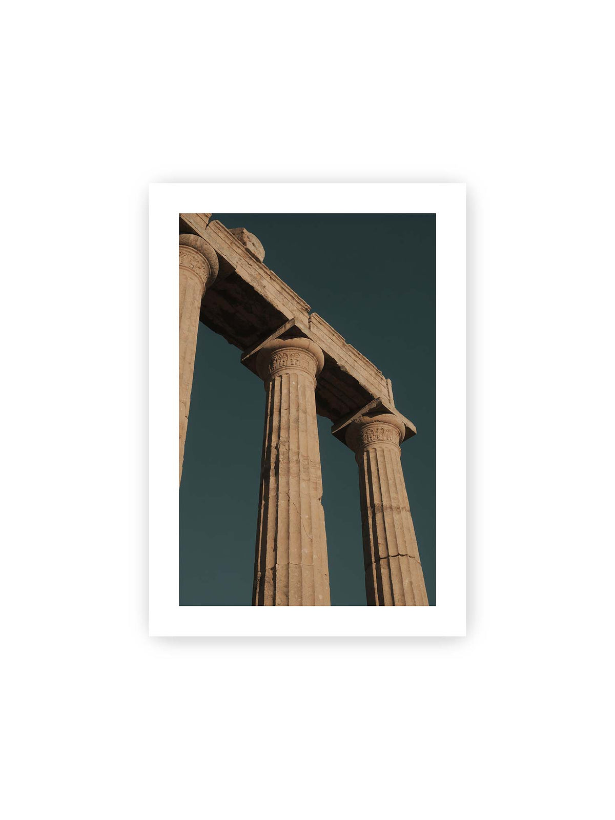 21x30 cm, weißer Galerie-Rand – Monumentale Steinsäulen mit verzierten Kapitellen und verwittertem Gebälk vor dunklem Himmel.