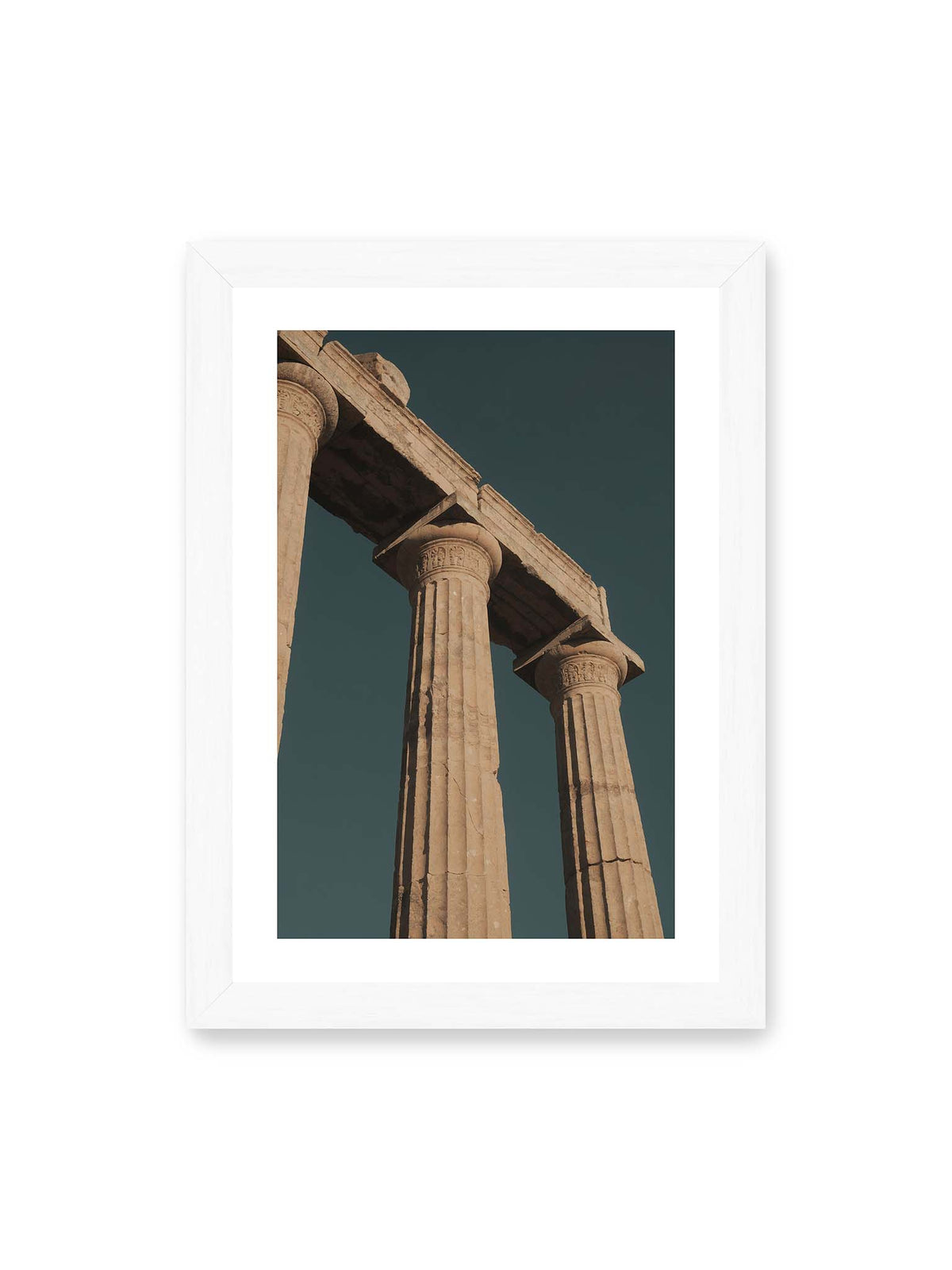 21x30 cm, weißer Galerie-Rand, weißer Rahmen – Monumentale Steinsäulen mit verzierten Kapitellen und verwittertem Gebälk vor dunklem Himmel.