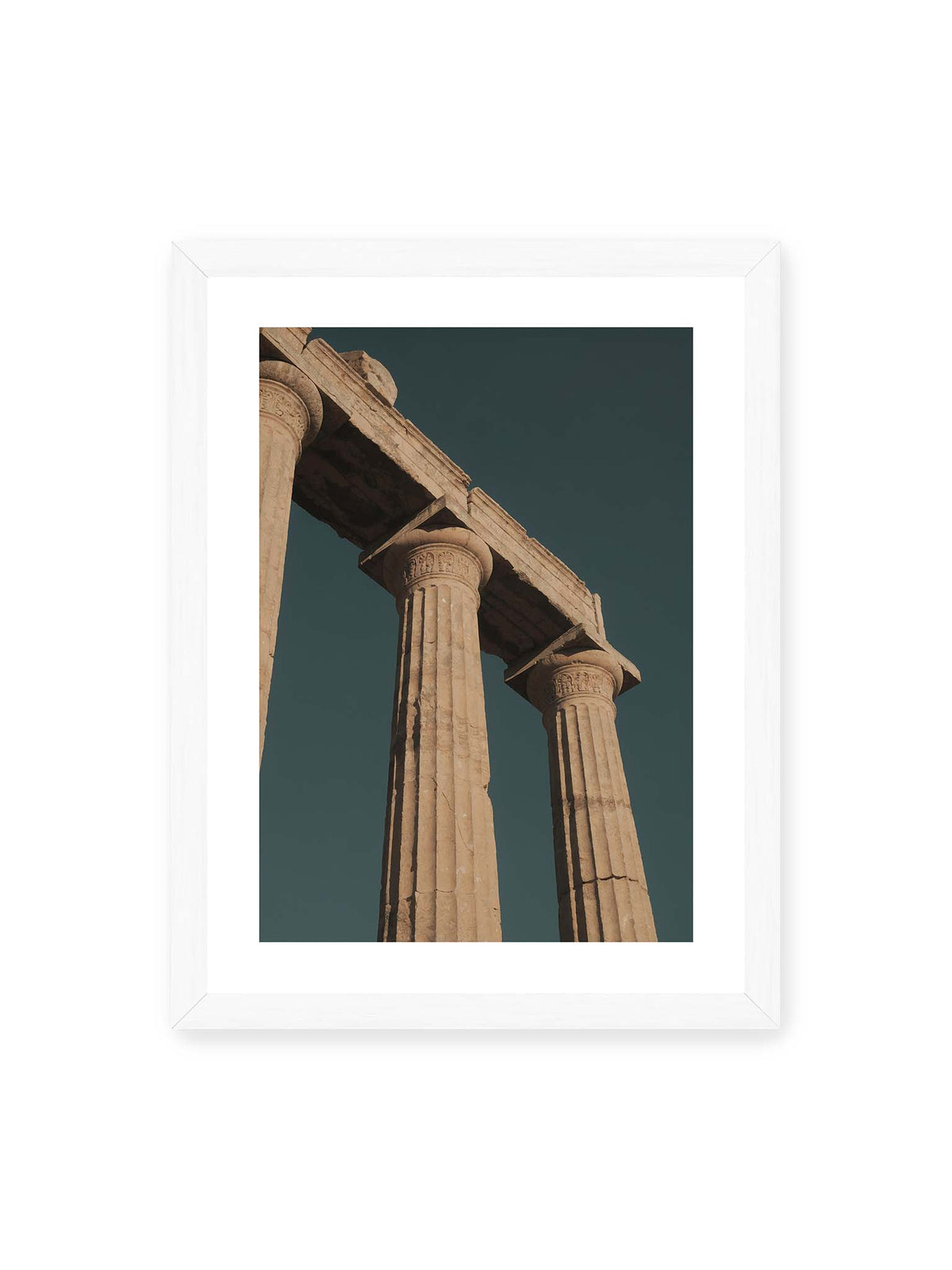 30x40 cm, weißer Galerie-Rand, weißer Rahmen – Monumentale Steinsäulen mit verzierten Kapitellen und verwittertem Gebälk vor dunklem Himmel.