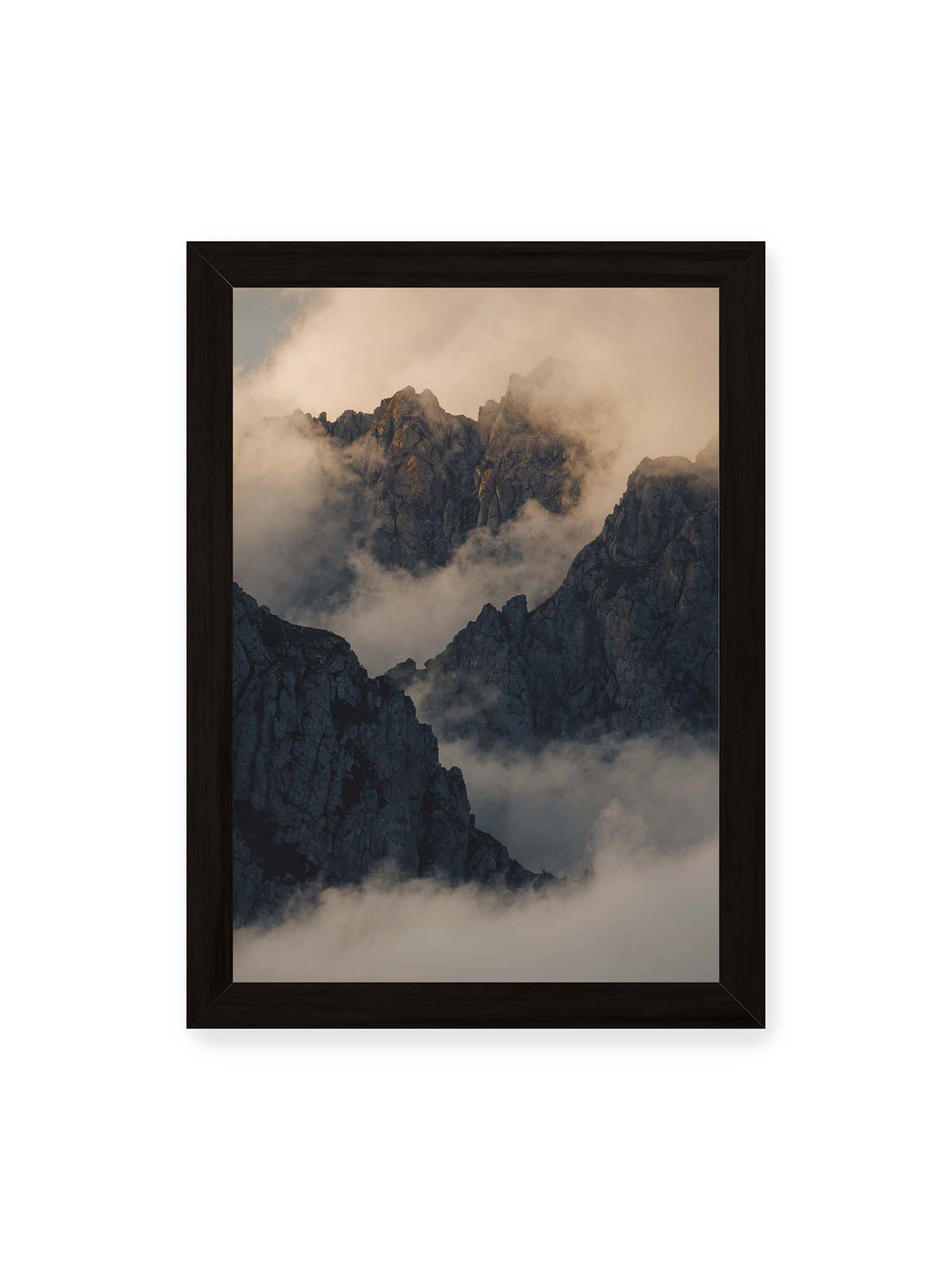 21x30 cm, schwarzer Rahmen – Zerklüftete dunkle Bergspitzen zwischen dichten Wolken mit warm beleuchteten Felsflächen.