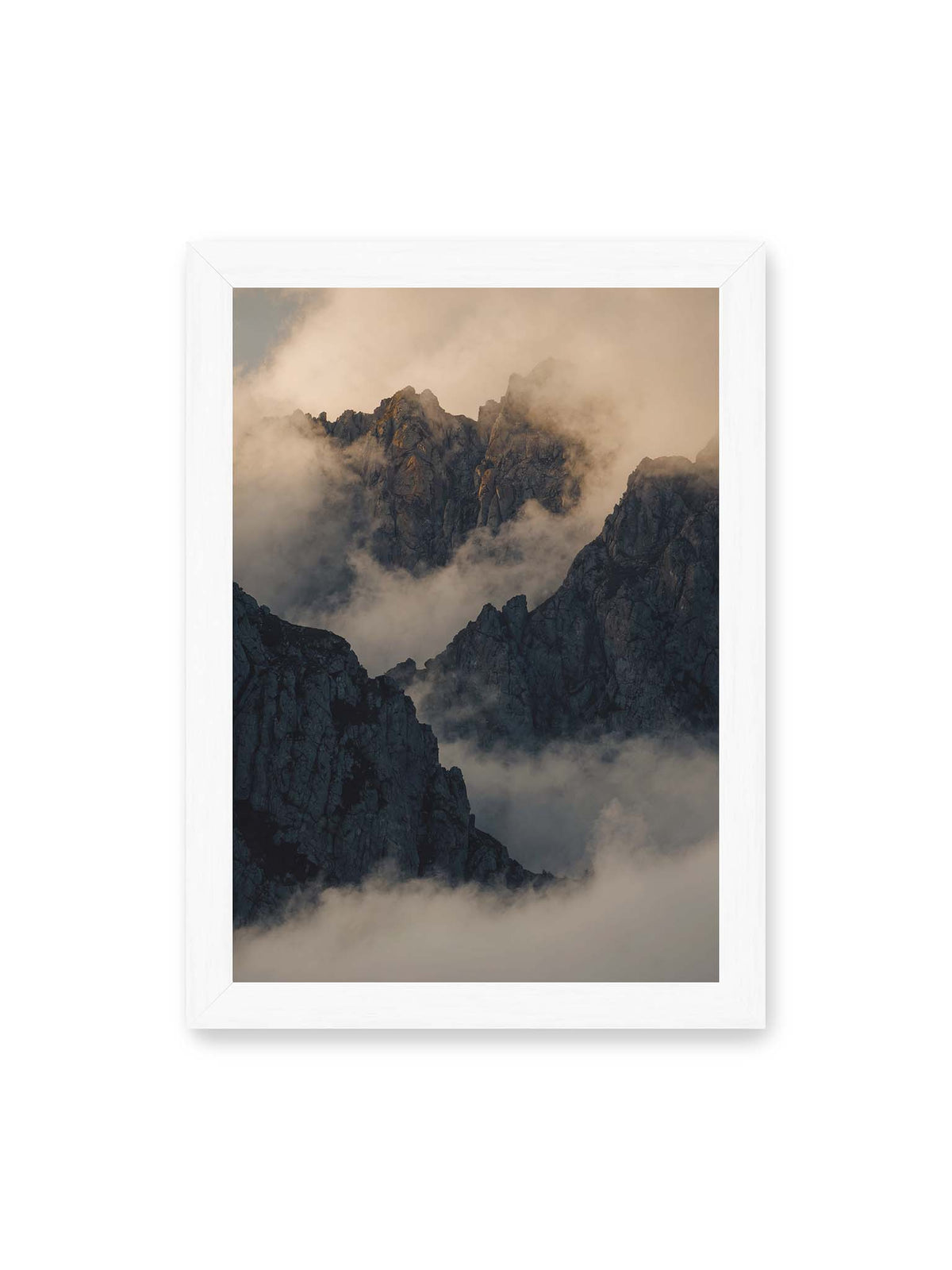 21x30 cm, weißer Rahmen – Zerklüftete dunkle Bergspitzen zwischen dichten Wolken mit warm beleuchteten Felsflächen.