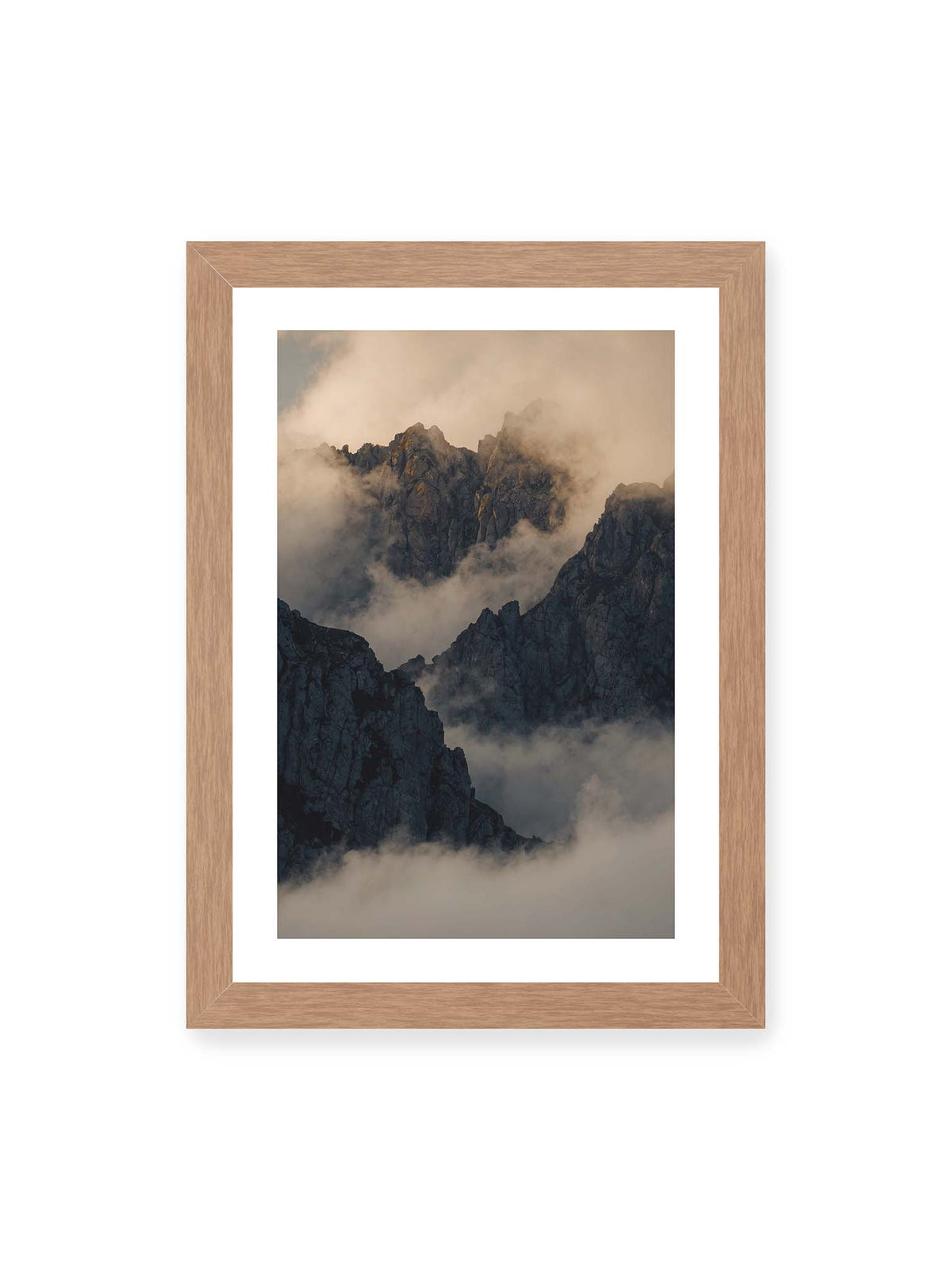 21x30 cm, weißer Galerie-Rand, Eichenrahmen – Zerklüftete dunkle Bergspitzen zwischen dichten Wolken mit warm beleuchteten Felsflächen.