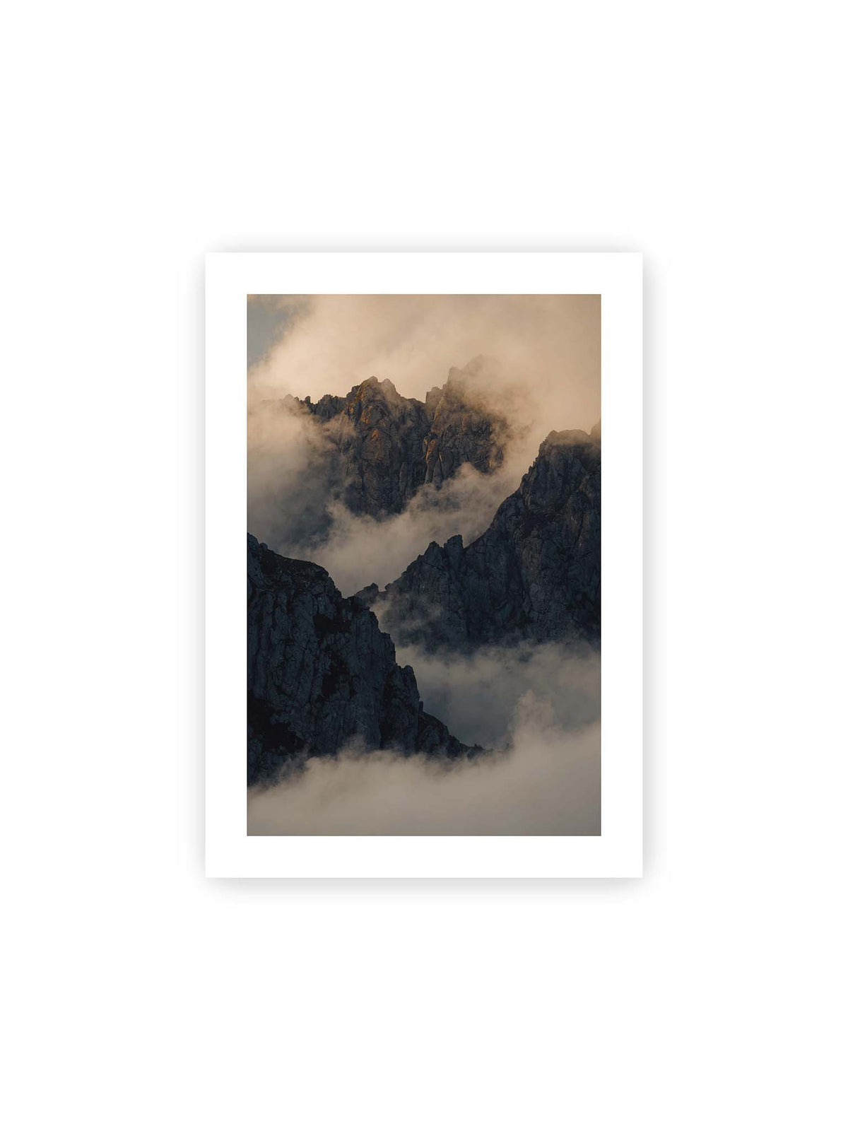 21x30 cm, weißer Galerie-Rand – Zerklüftete dunkle Bergspitzen zwischen dichten Wolken mit warm beleuchteten Felsflächen.