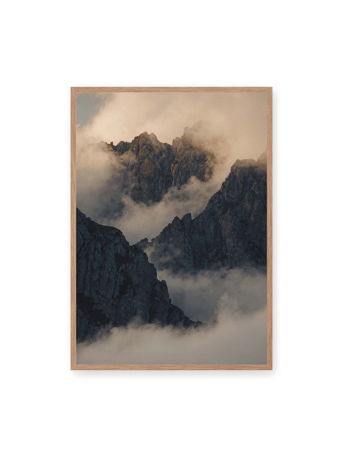 70x100 cm, Eichenrahmen – Zerklüftete dunkle Bergspitzen zwischen dichten Wolken mit warm beleuchteten Felsflächen.