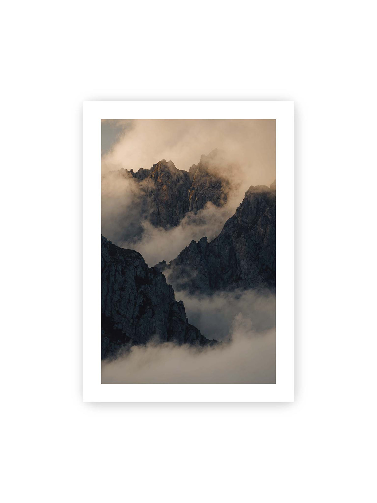 70x100 cm, weißer Galerie-Rand – Zerklüftete dunkle Bergspitzen zwischen dichten Wolken mit warm beleuchteten Felsflächen.