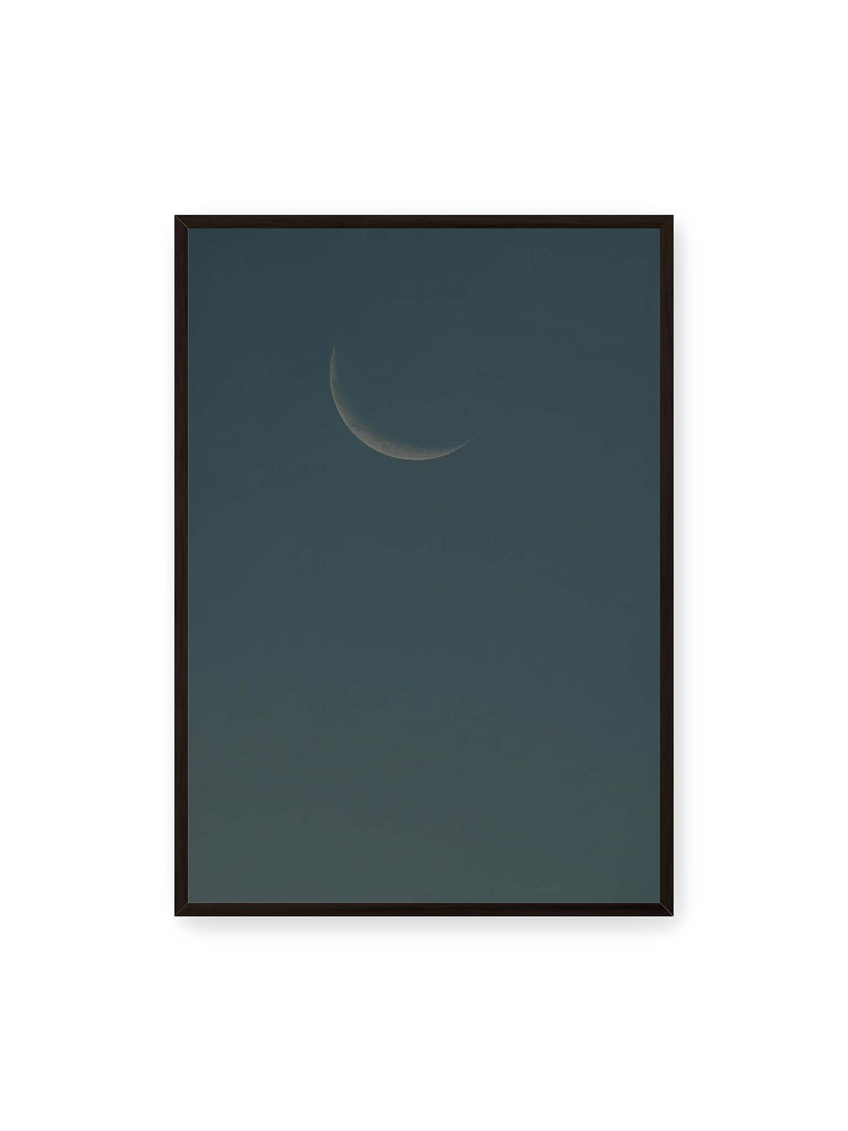 70x100 cm, schwarzer Rahmen – Schmale Mondsichel mit feiner Oberflächenstruktur vor einer weitläufigen dunkelblauen Himmelsfläche.