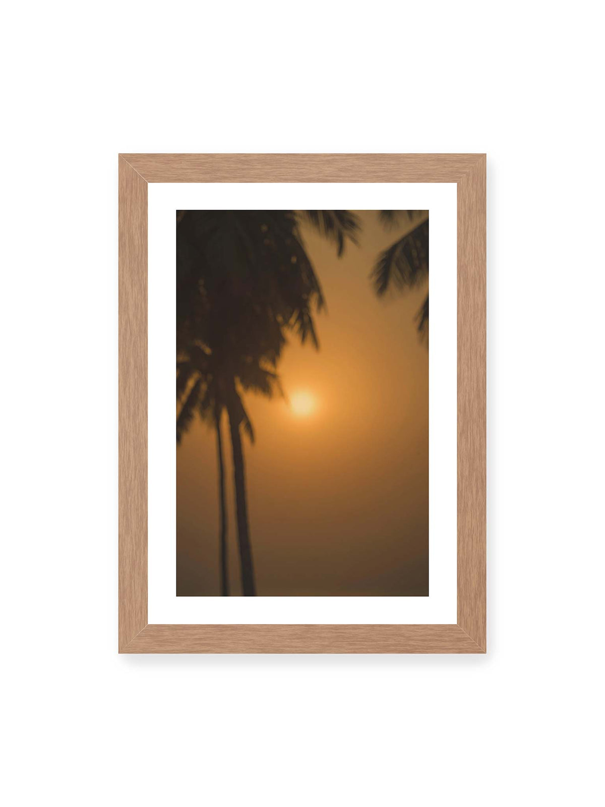 21x30 cm, weißer Galerie-Rand, Eichenrahmen – Unscharfe dunkle Palmen vor goldenem Himmel mit einer hell leuchtenden Sonne zwischen den Silhouetten.