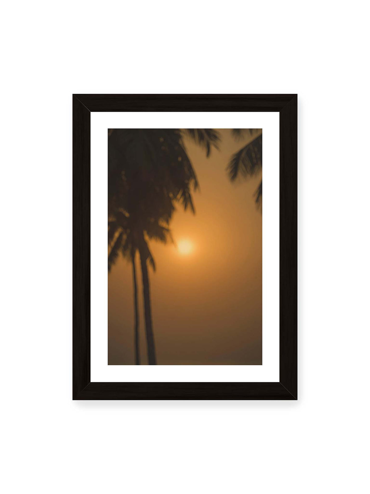 21x30 cm, weißer Galerie-Rand, schwarzer Rahmen – Unscharfe dunkle Palmen vor goldenem Himmel mit einer hell leuchtenden Sonne zwischen den Silhouetten.