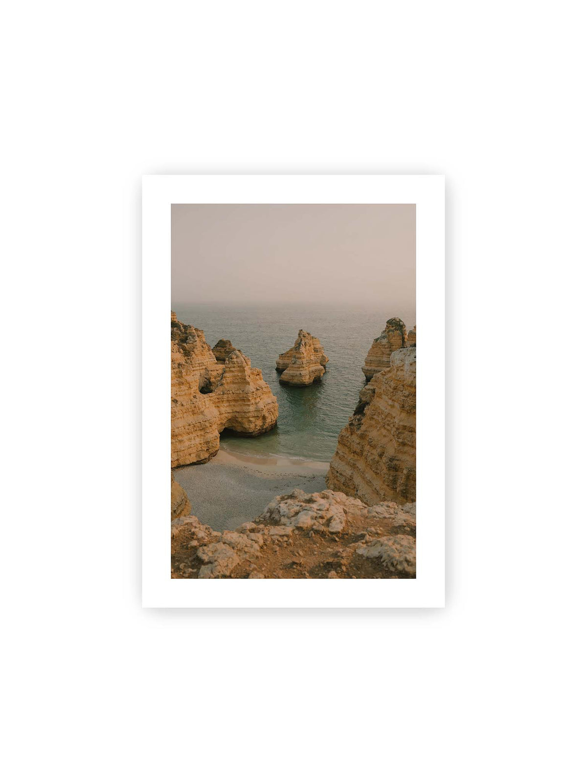 21x30 cm, weißer Galerie-Rand – Schichtartige Felsformationen umgeben eine kleine Bucht mit ruhigem Wasser und schmalem Sandstrand.