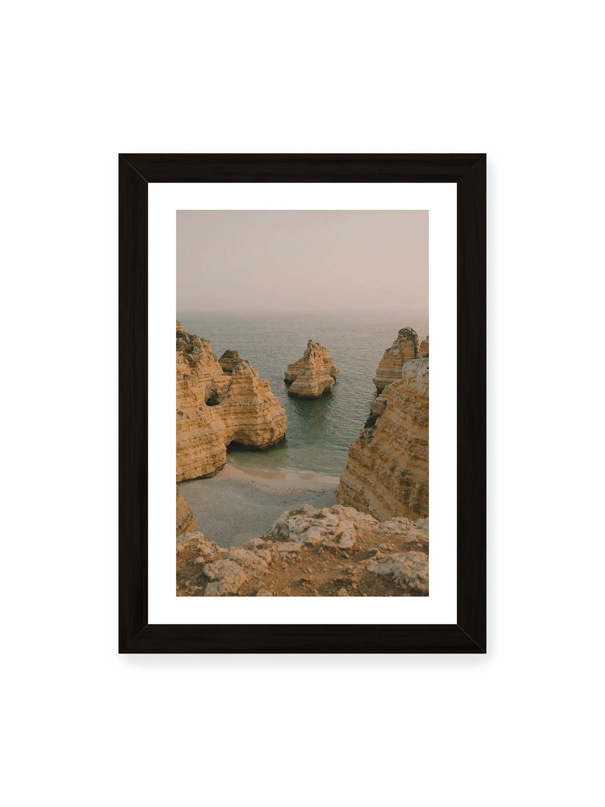 21x30 cm, weißer Galerie-Rand, schwarzer Rahmen – Schichtartige Felsformationen umgeben eine kleine Bucht mit ruhigem Wasser und schmalem Sandstrand.