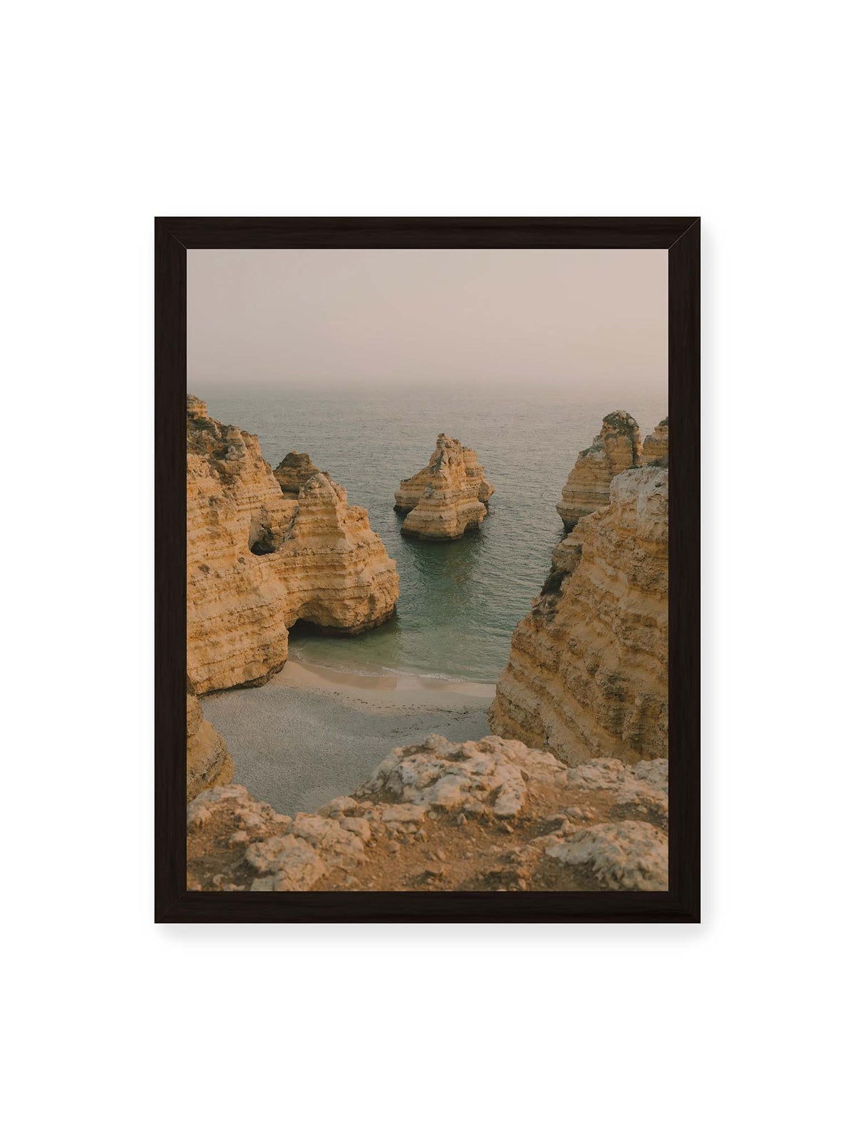 30x40 cm, schwarzer Rahmen – Schichtartige Felsformationen umgeben eine kleine Bucht mit ruhigem Wasser und schmalem Sandstrand.