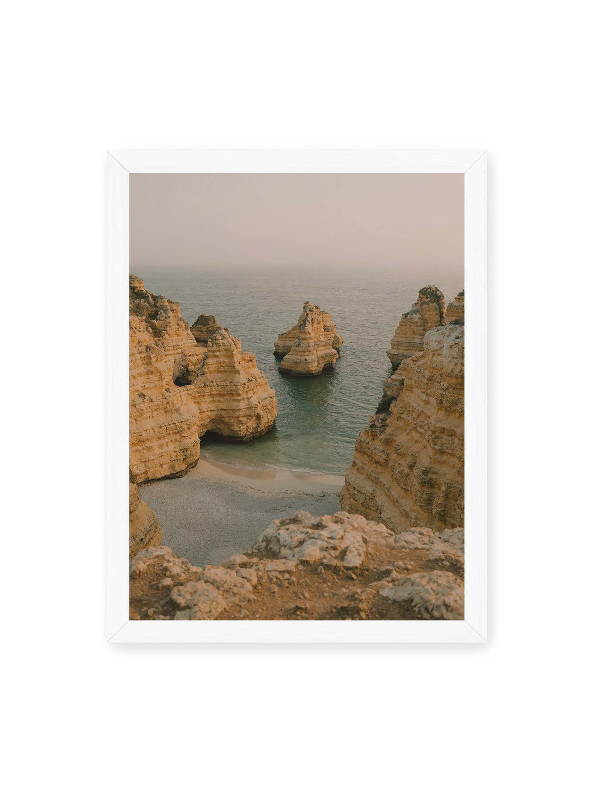 30x40 cm, weißer Rahmen – Schichtartige Felsformationen umgeben eine kleine Bucht mit ruhigem Wasser und schmalem Sandstrand.
