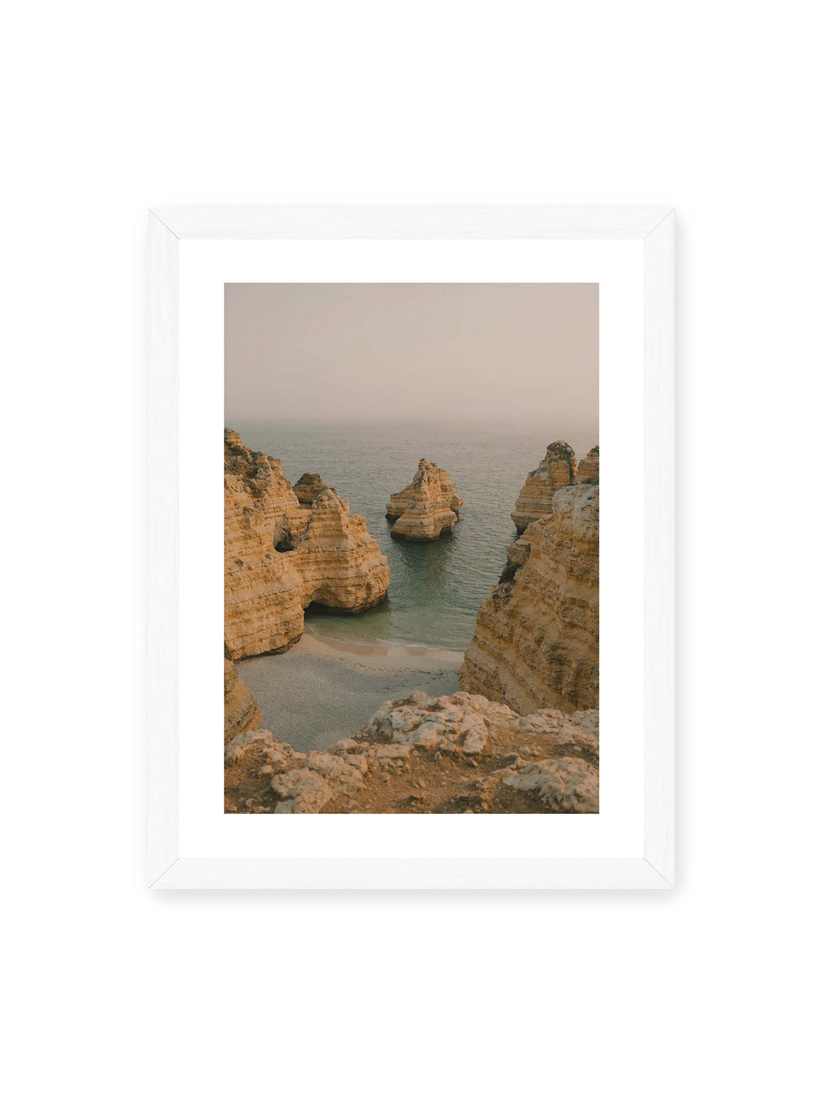 30x40 cm, weißer Galerie-Rand, weißer Rahmen – Schichtartige Felsformationen umgeben eine kleine Bucht mit ruhigem Wasser und schmalem Sandstrand.