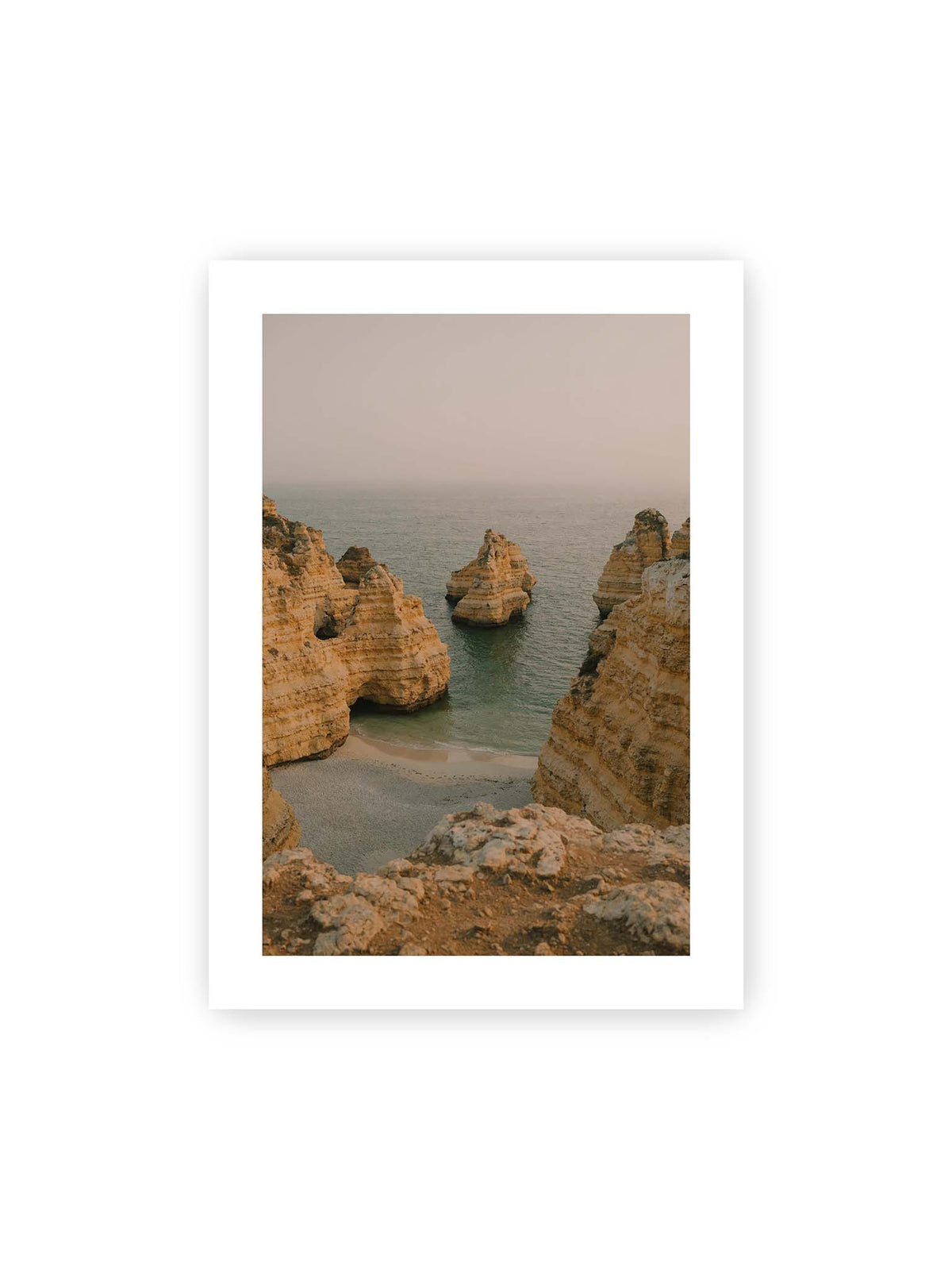 50x70 cm, weißer Galerie-Rand – Schichtartige Felsformationen umgeben eine kleine Bucht mit ruhigem Wasser und schmalem Sandstrand.