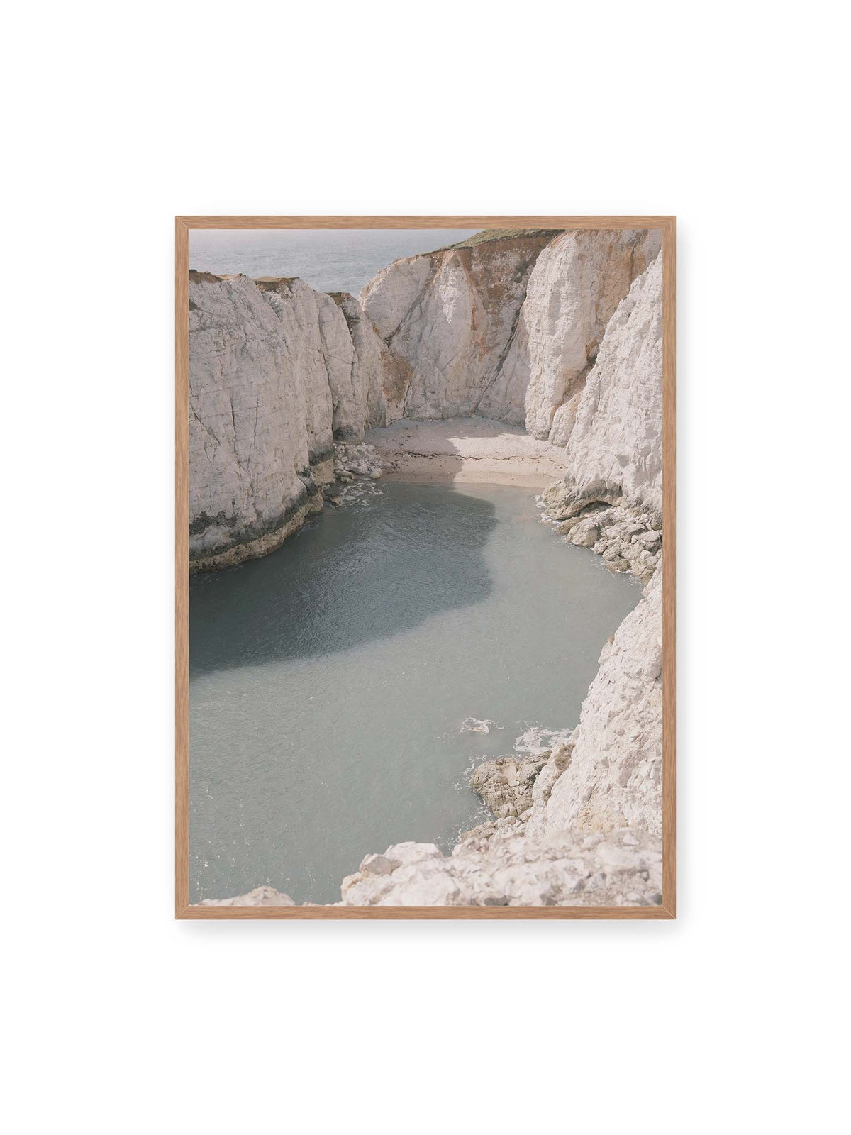 70x100 cm, Eichenrahmen – Helle steile Felswände umschließen eine kleine Bucht mit ruhigem Wasser und einem schmalen Strand.