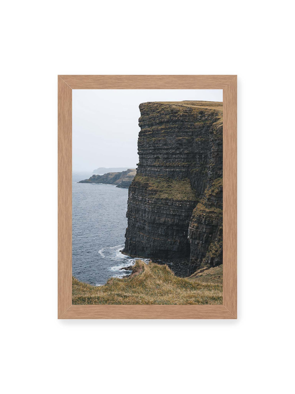 21x30 cm, Eichenrahmen – Dunkle geschichtete Klippen fallen steil zum Meer ab, während weitere Felswände in der hellen Ferne verschwinden.