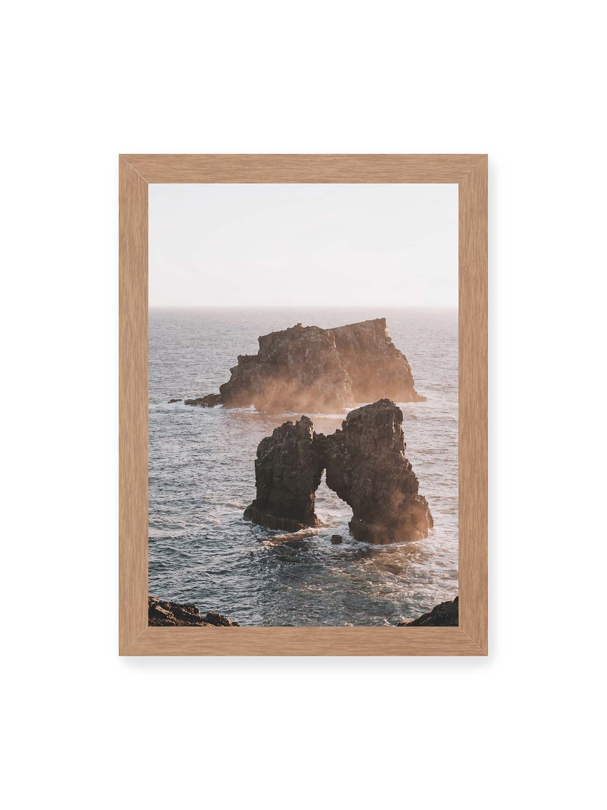 21x30 cm, Eichenrahmen – Dunkler Felsbogen und massive Felsformation im bewegten Meer, umgeben von heller Gischt und warmem Licht.