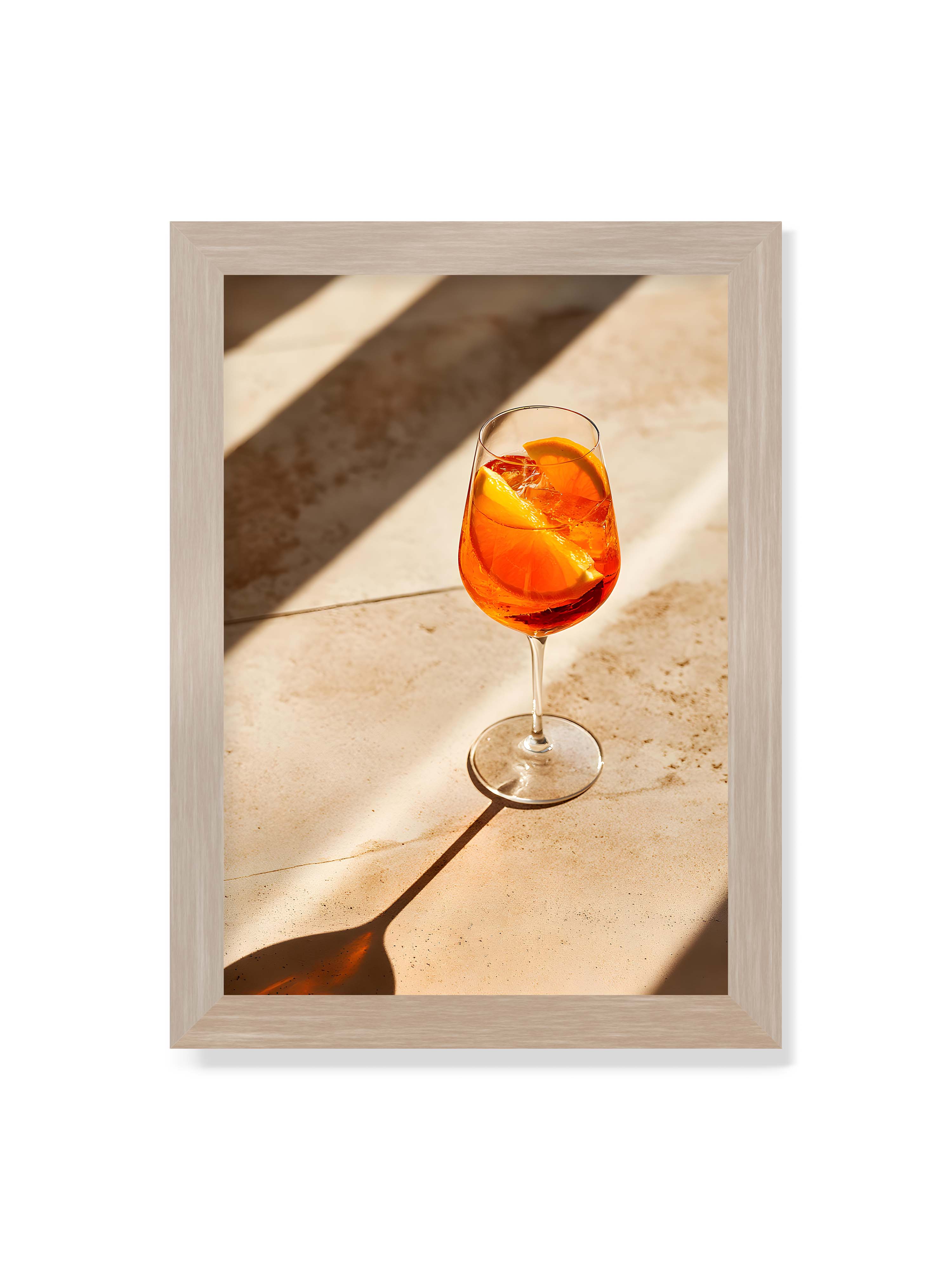 21x30 cm ohne Galerie-Rand im Eichenrahmen – Aperitifglas mit orangefarbenem Drink und Orangenscheiben, Sonnenlicht und langer Schatten auf hellem Stein.