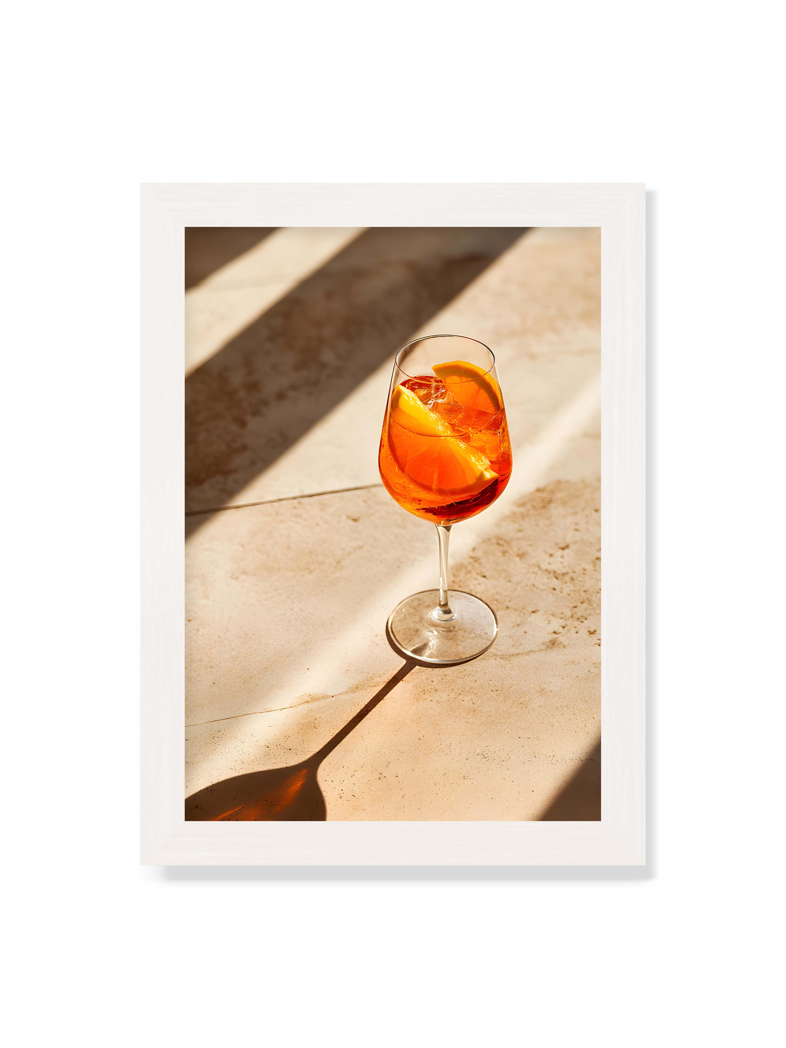 21x30 cm ohne Galerie-Rand mit weißem Rahmen – Aperitifglas mit orangefarbenem Drink und Orangenscheiben, Sonnenlicht und langer Schatten auf hellem Stein.