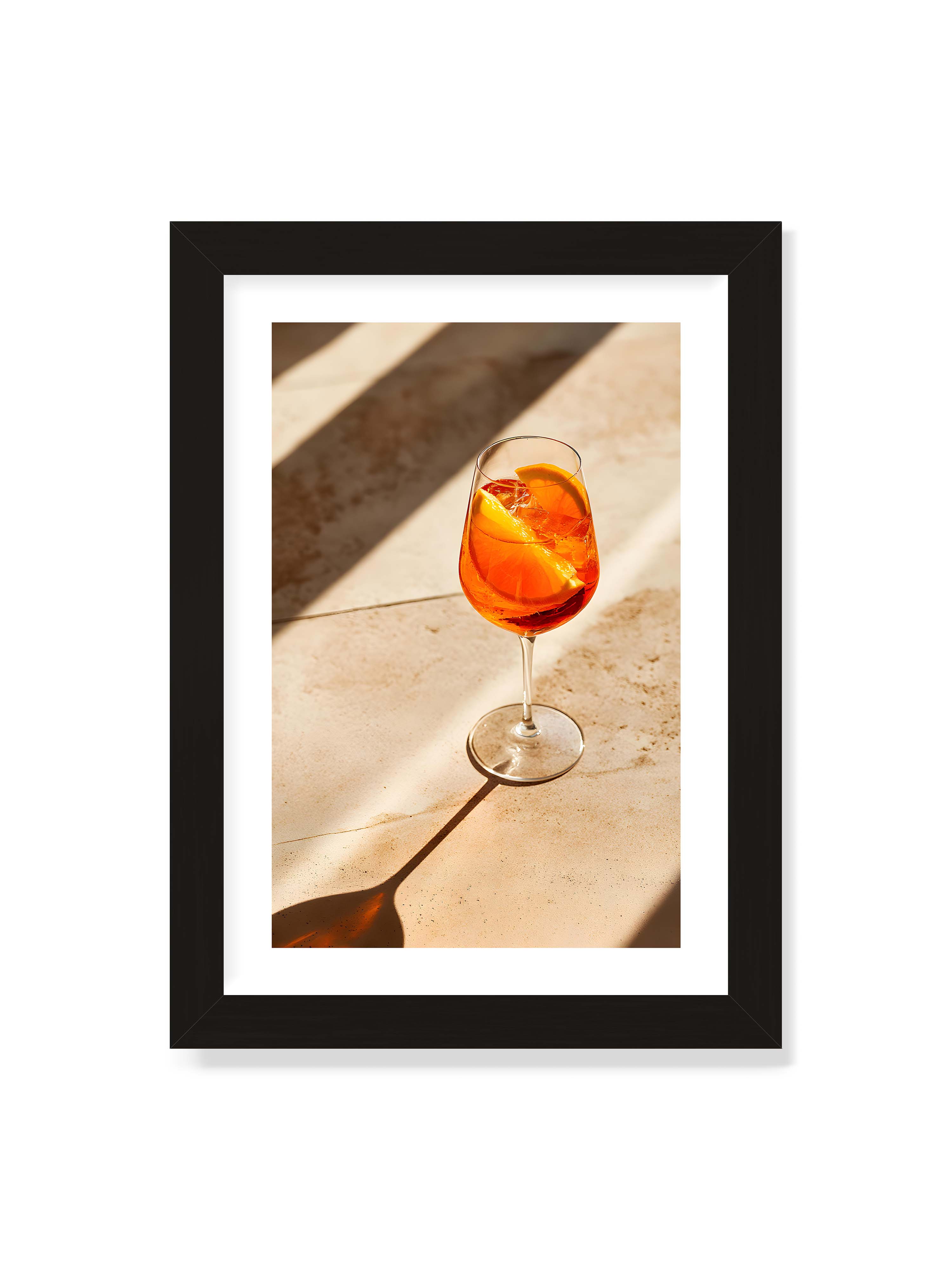 21x30 cm mit weißem Galerie-Rand mit schwarzem Rahmen – Aperitifglas mit orangefarbenem Drink und Orangenscheiben, Sonnenlicht und langer Schatten auf hellem Stein.