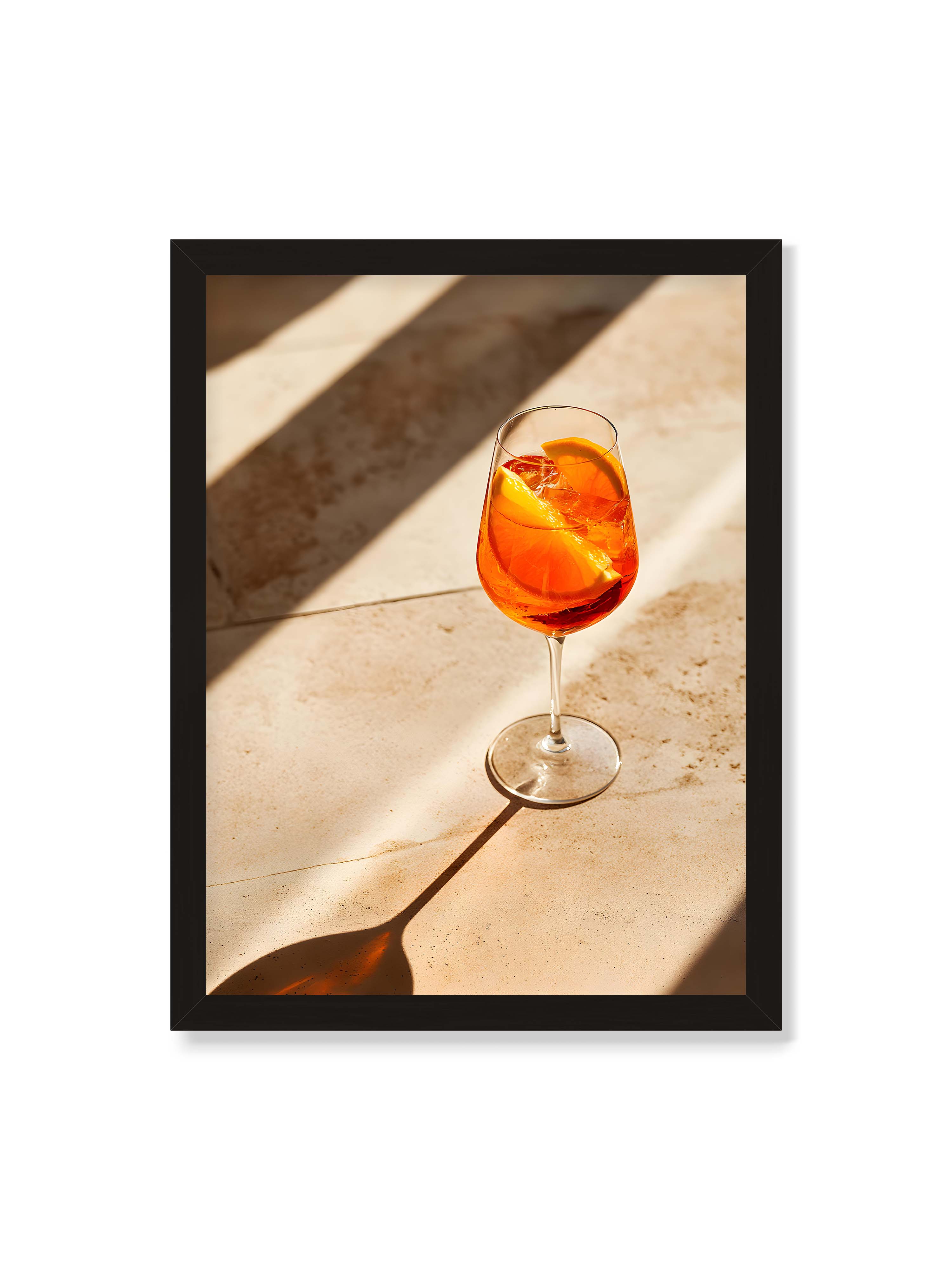 30x40 cm ohne Galerie-Rand mit schwarzem Rahmen – Aperitifglas mit orangefarbenem Drink und Orangenscheiben, Sonnenlicht und langer Schatten auf hellem Stein.