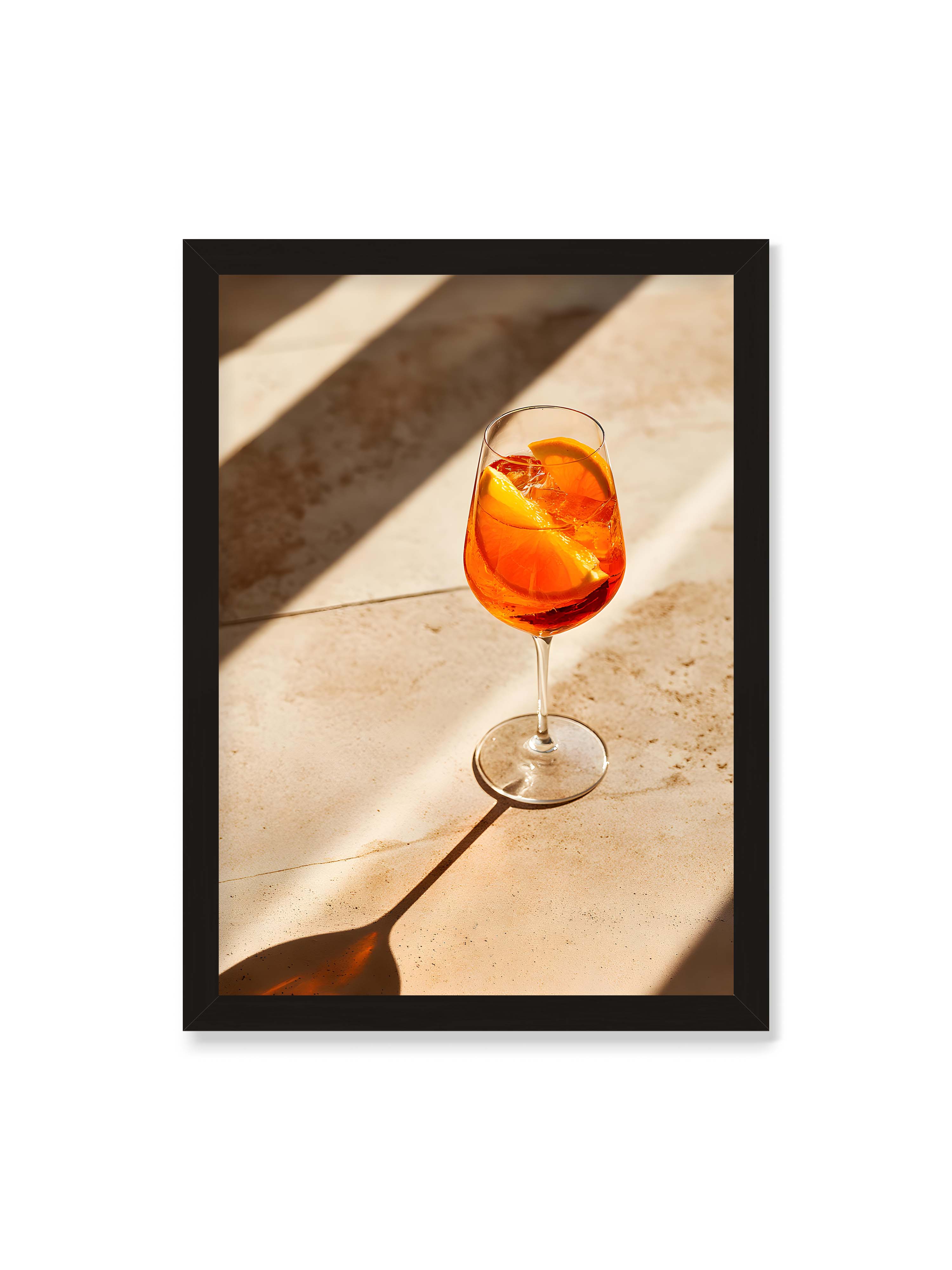 50x70 cm ohne Galerie-Rand mit schwarzem Rahmen – Aperitifglas mit orangefarbenem Drink und Orangenscheiben, Sonnenlicht und langer Schatten auf hellem Stein.