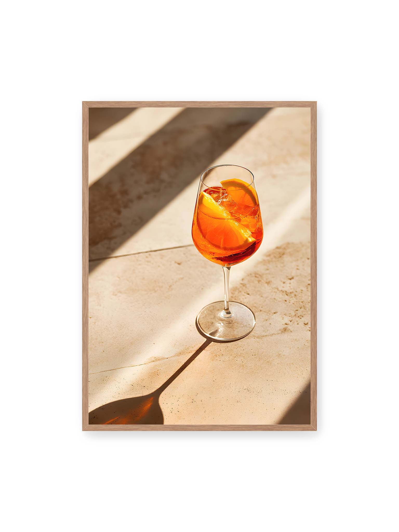 70x100 cm, Eichenrahmen – Aperitifglas mit orangefarbenem Drink und Orangenscheiben, Sonnenlicht und langer Schatten auf hellem Stein.