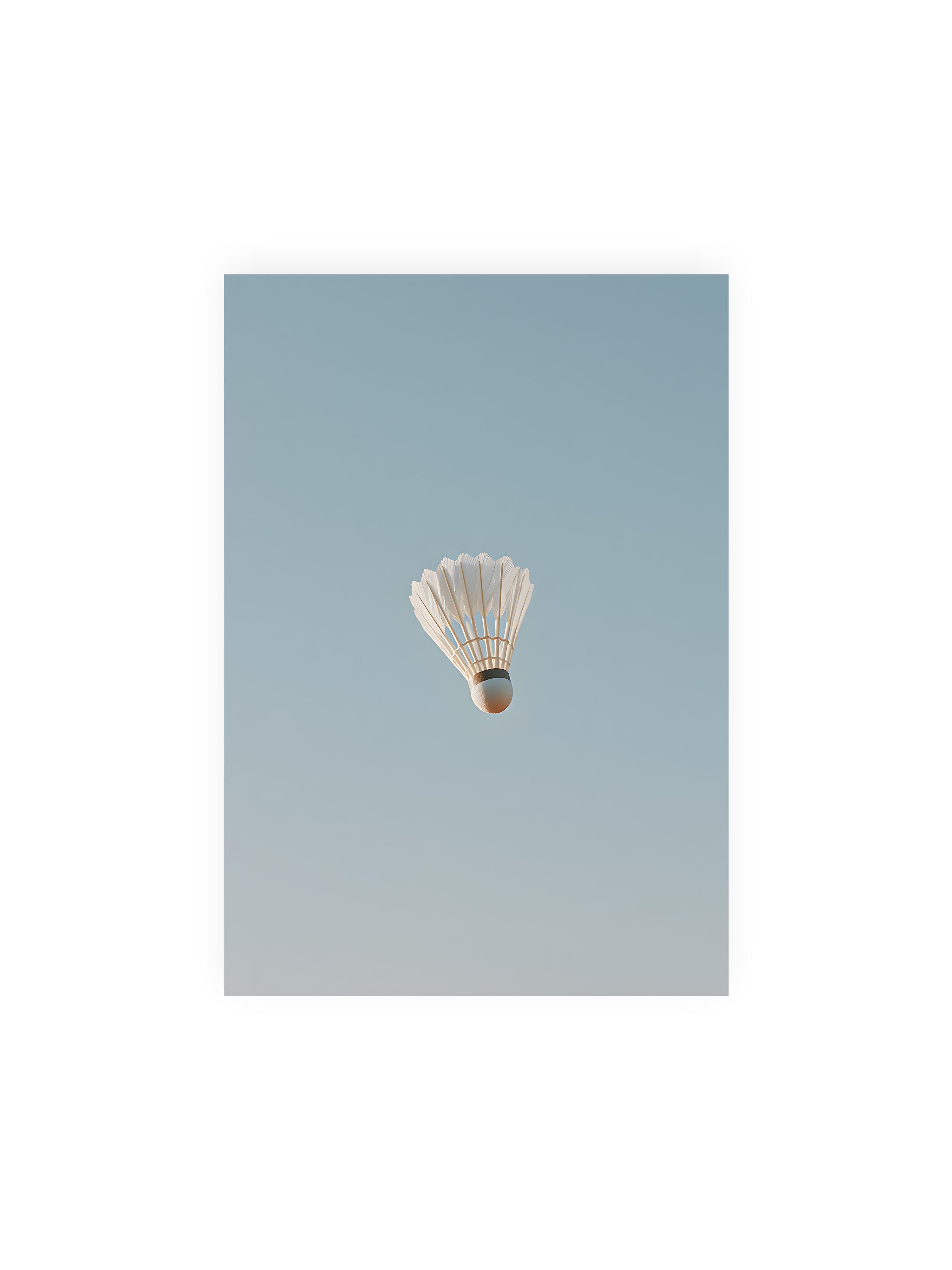 21x30 cm ohne Galerie-Rand ohne Rahmen – Weißer Federball schwebt zentriert vor hellblauem Himmel, minimalistische Komposition mit viel Freiraum.