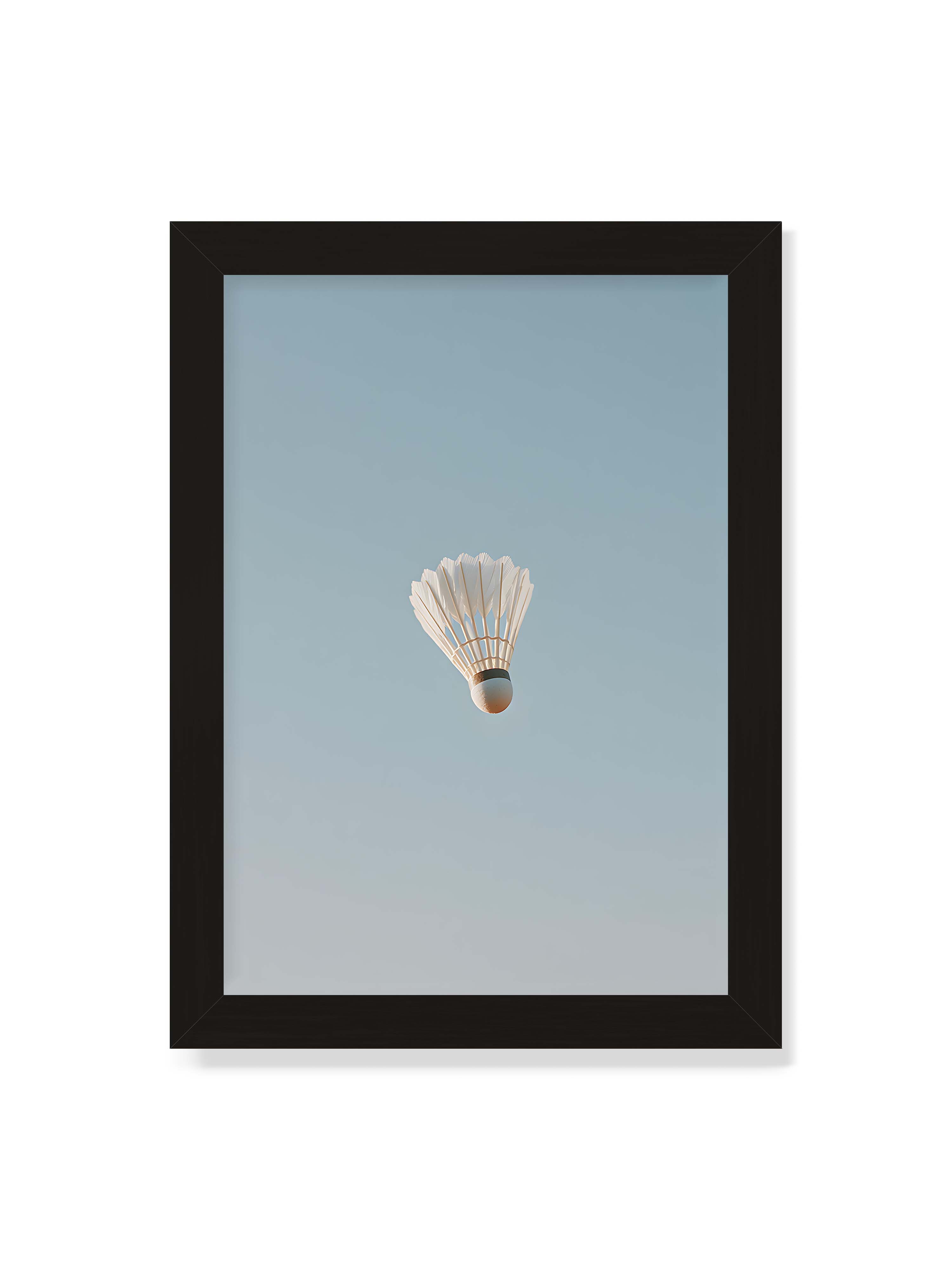 21x30 cm ohne Galerie-Rand mit schwarzem Rahmen – Weißer Federball schwebt zentriert vor hellblauem Himmel, minimalistische Komposition mit viel Freiraum.