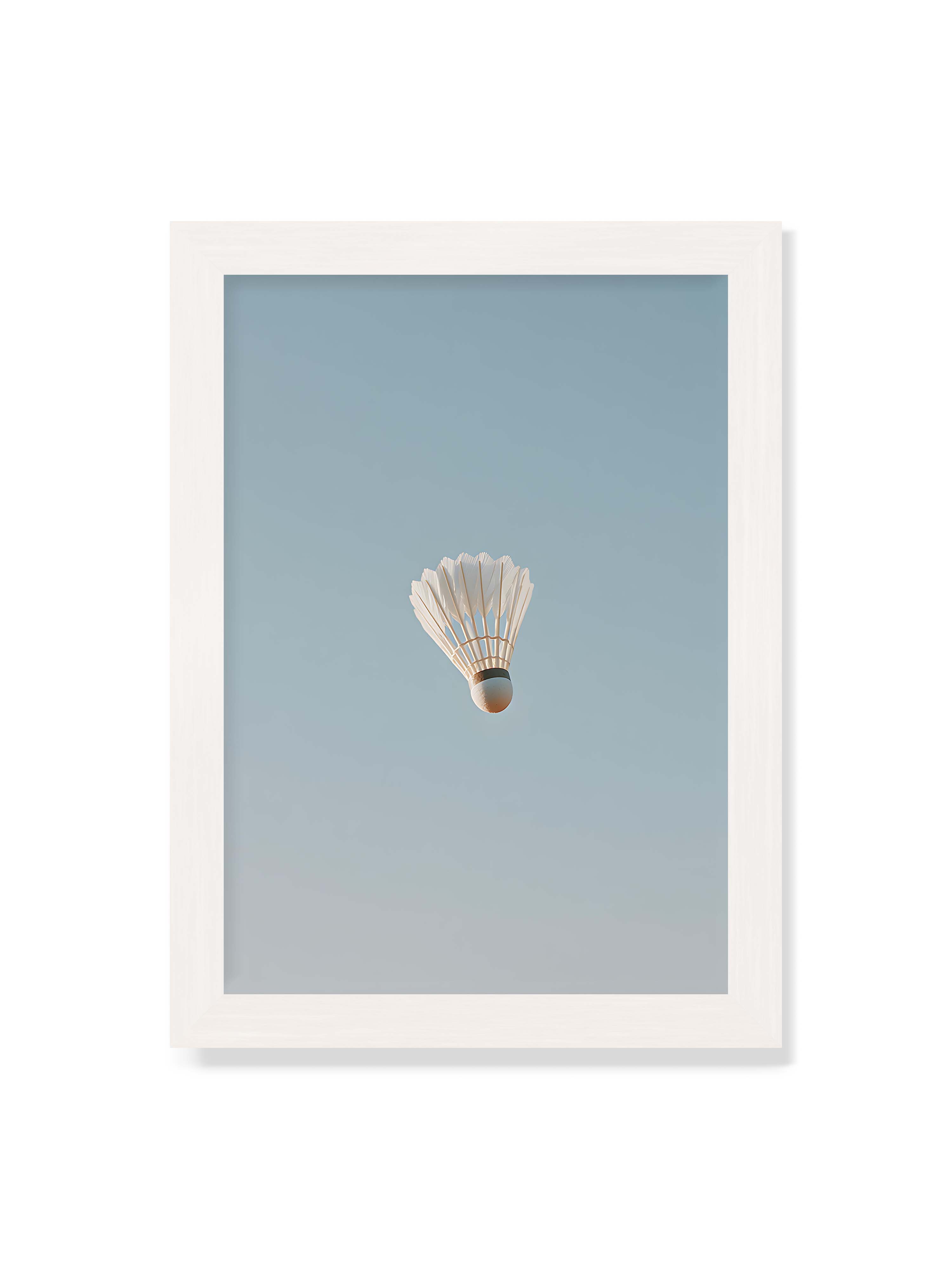 21x30 cm ohne Galerie-Rand mit weißem Rahmen – Weißer Federball schwebt zentriert vor hellblauem Himmel, minimalistische Komposition mit viel Freiraum.