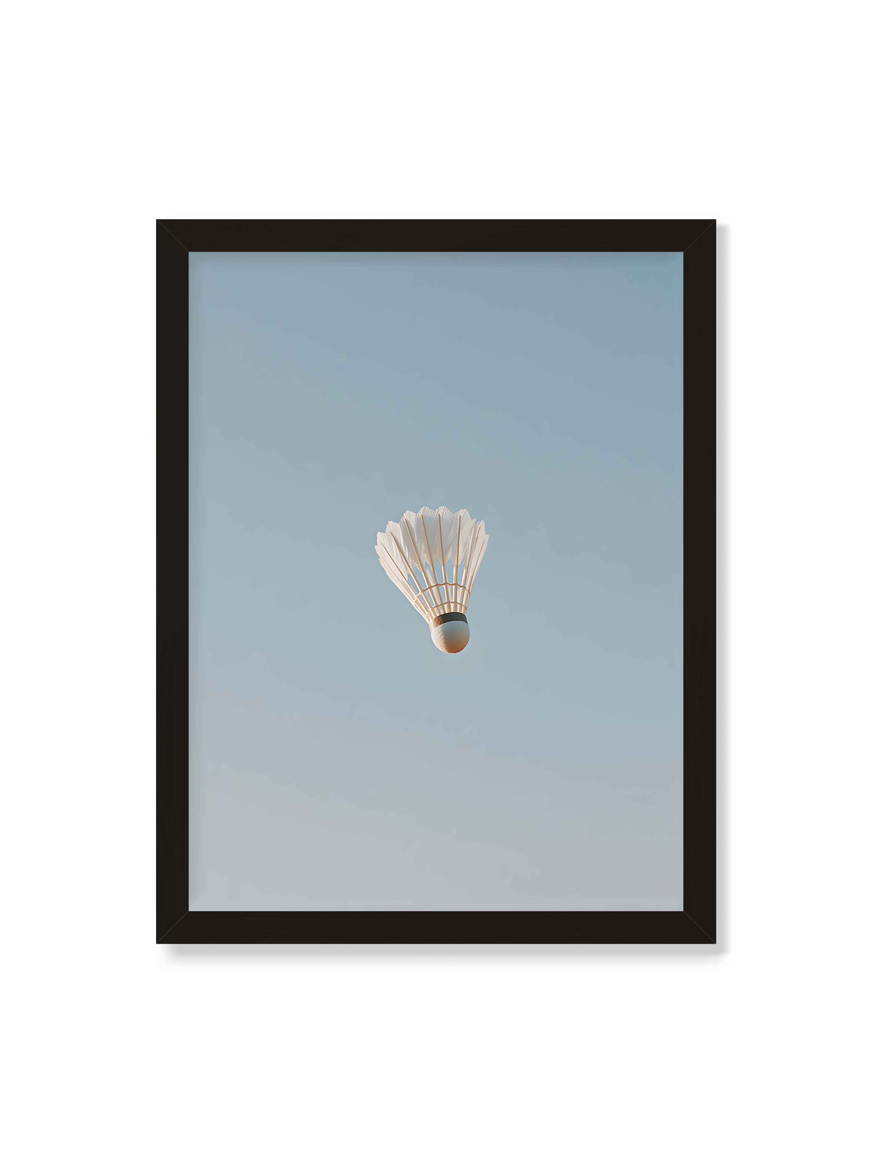 30x40 cm ohne Galerie-Rand mit schwarzem Rahmen – Weißer Federball schwebt zentriert vor hellblauem Himmel, minimalistische Komposition mit viel Freiraum.