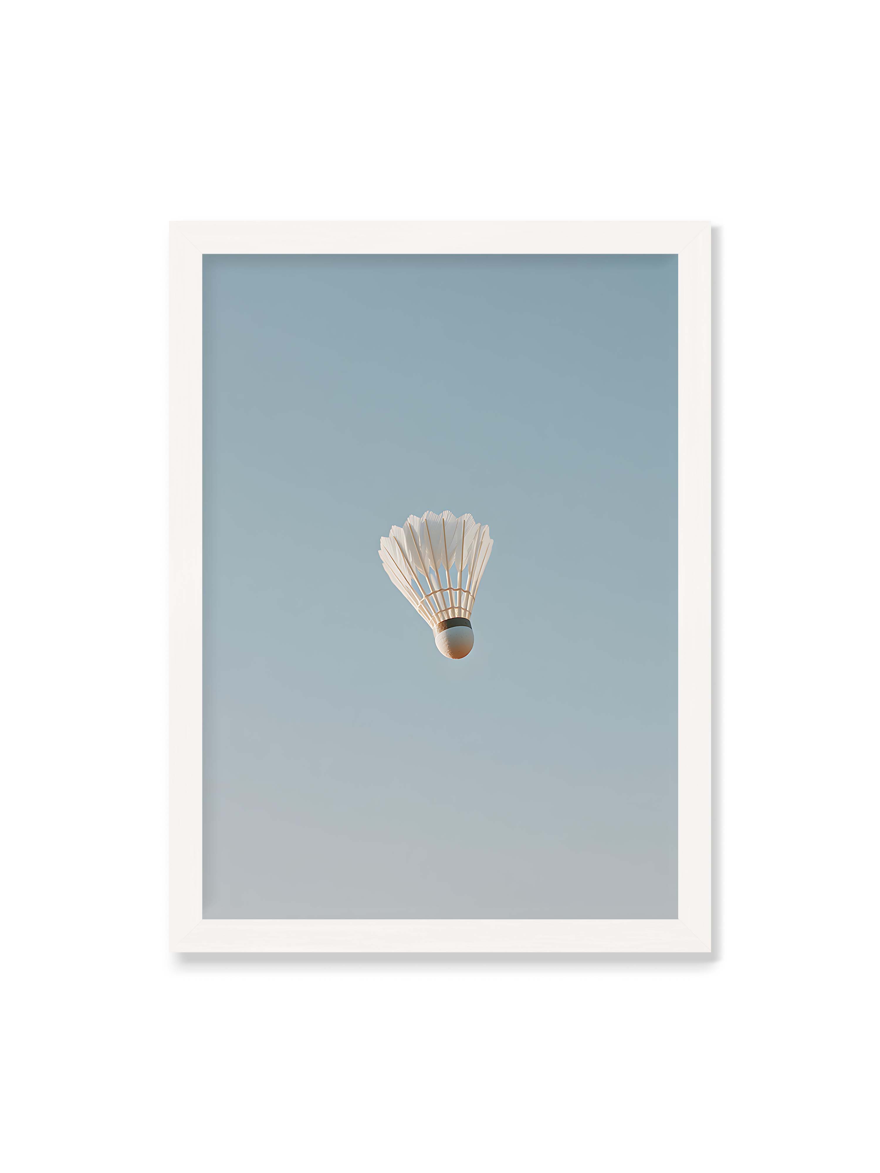 50x70 cm ohne Galerie-Rand mit weißem Rahmen – Weißer Federball schwebt zentriert vor hellblauem Himmel, minimalistische Komposition mit viel Freiraum.