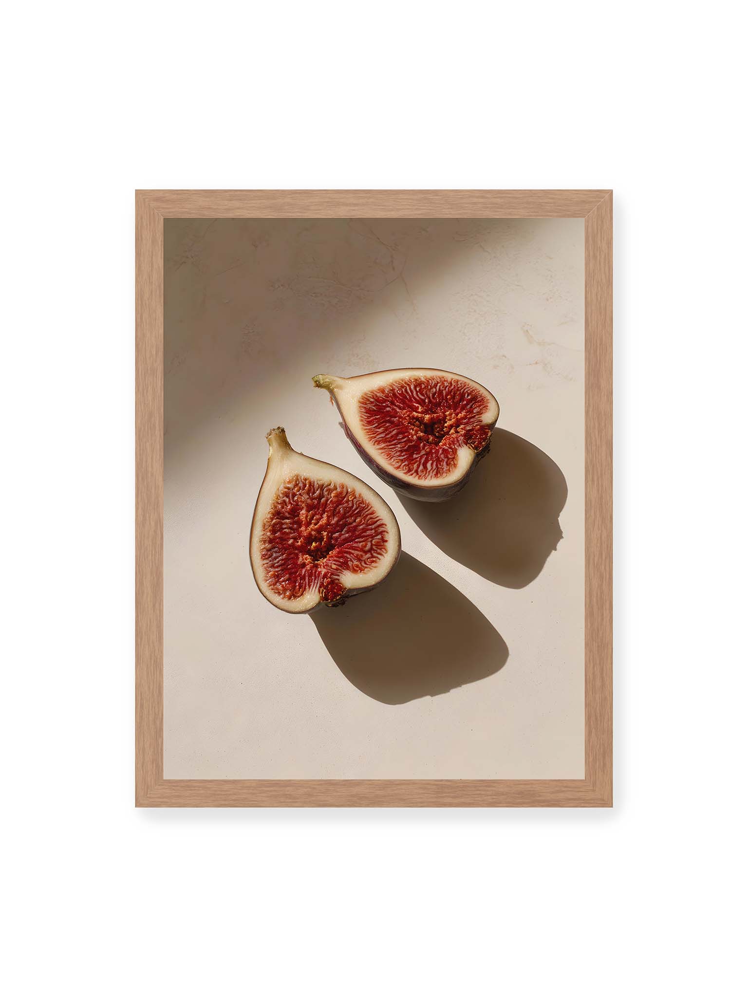 30x40 cm, Eichenrahmen – Halbierte Feigen auf heller Oberfläche mit warmem Licht und langen Schatten, sichtbar strukturierte rote Fruchtmitte.