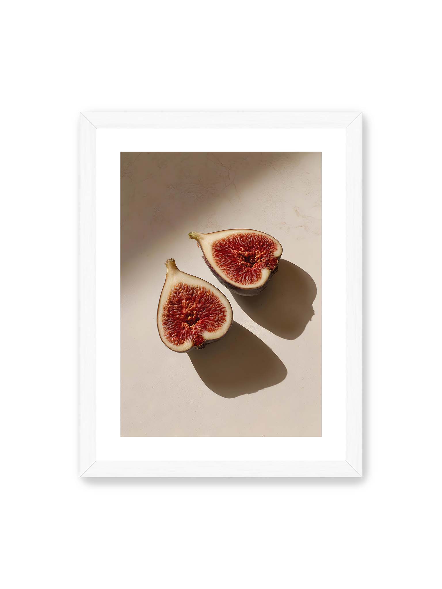 30x40 cm, weißer Galerie-Rand, weißer Rahmen – Halbierte Feigen auf heller Oberfläche mit warmem Licht und langen Schatten, sichtbar strukturierte rote Fruchtmitte.
