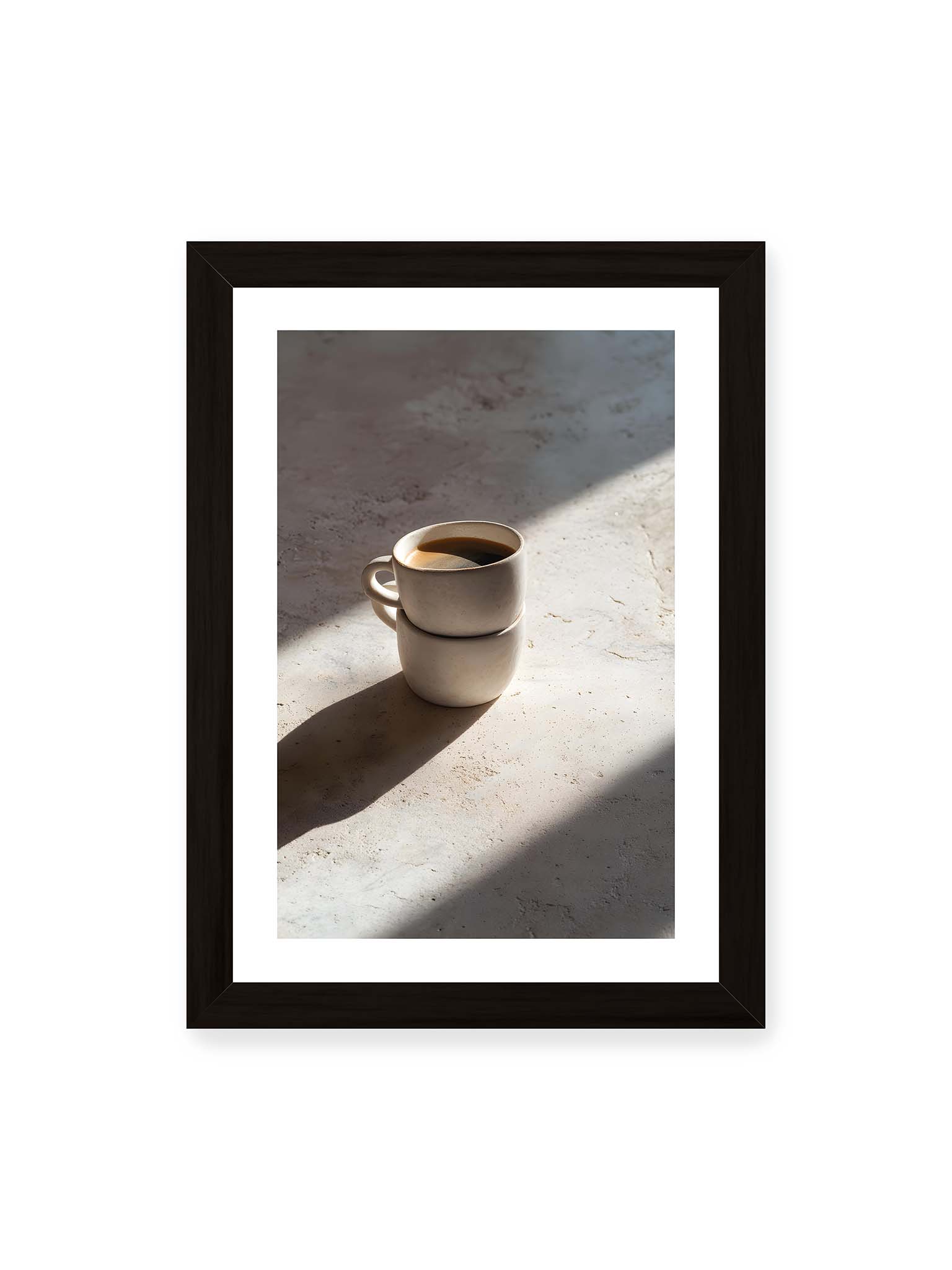 21x30 cm, weißer Galerie-Rand, schwarzer Rahmen – Zwei gestapelte Keramiktassen mit schwarzem Kaffee auf heller Oberfläche, beleuchtet von schrägem Morgenlicht mit langen Schatten.