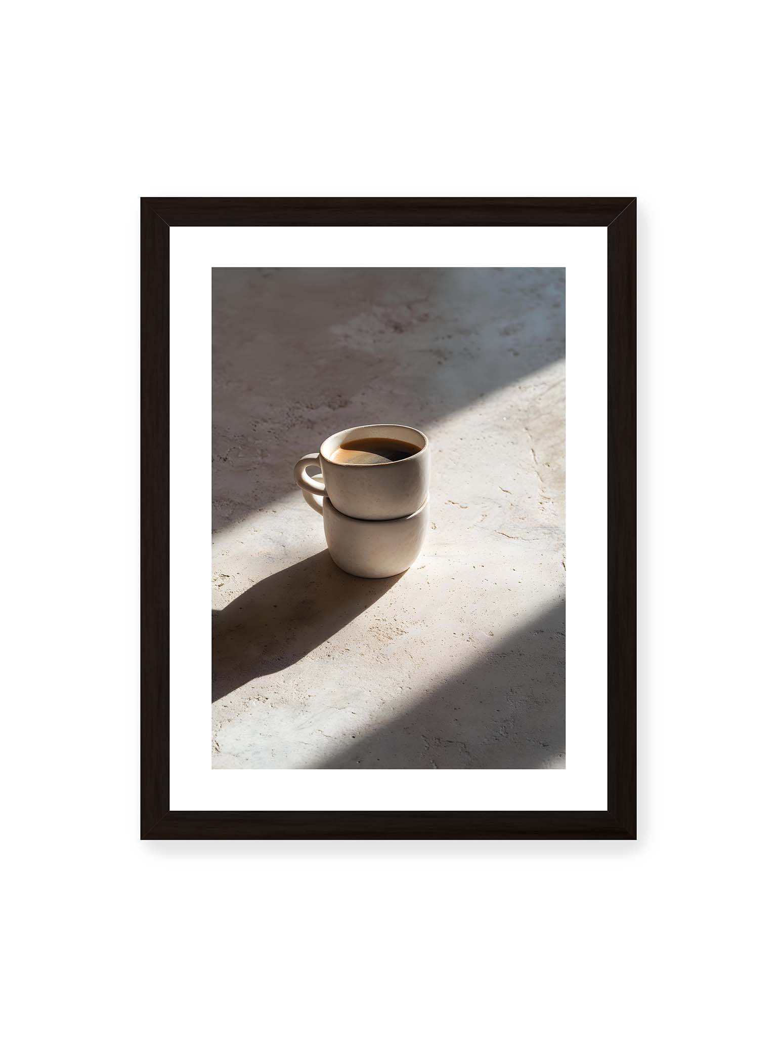 30x40 cm, weißer Galerie-Rand, schwarzer Rahmen – Zwei gestapelte Keramiktassen mit schwarzem Kaffee auf heller Oberfläche, beleuchtet von schrägem Morgenlicht mit langen Schatten.