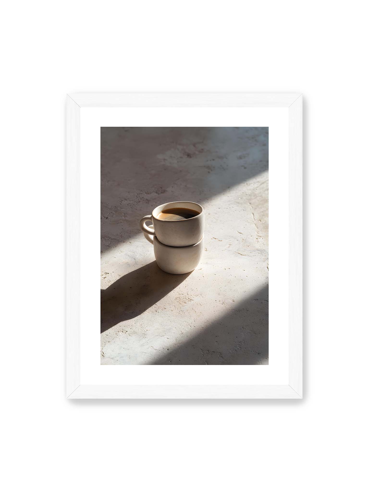 30x40 cm, weißer Galerie-Rand, weißer Rahmen – Zwei gestapelte Keramiktassen mit schwarzem Kaffee auf heller Oberfläche, beleuchtet von schrägem Morgenlicht mit langen Schatten.