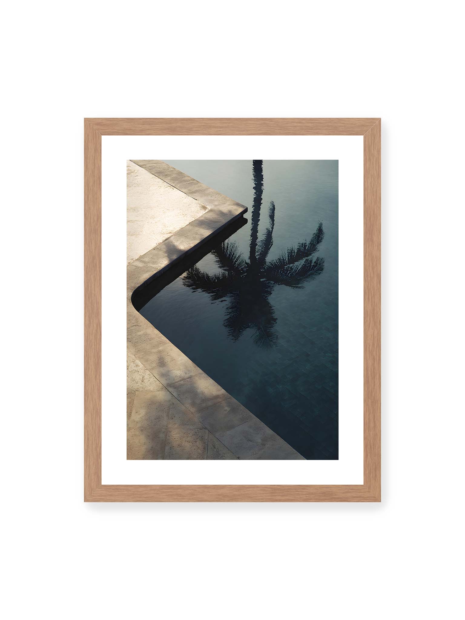 30x40 cm, weißer Galerie-Rand, Eichenrahmen – Spiegelung einer Palme im ruhigen Poolwasser neben heller Steinkante, klare Linien und dunkle Reflexion im Wasser.