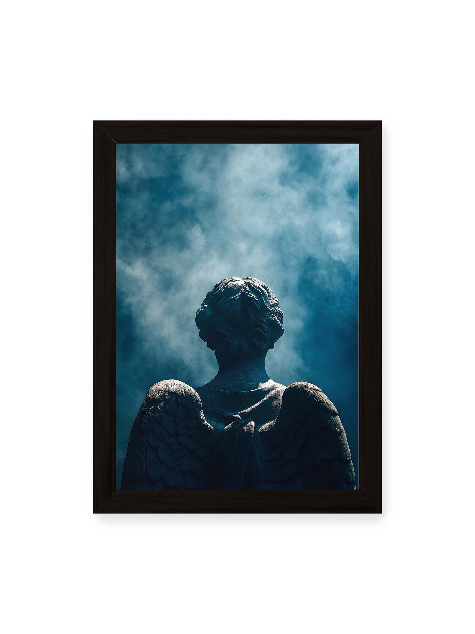 21x30 cm, schwarzer Rahmen – Rückansicht einer steinernen Engelsfigur mit ausgebreiteten Flügeln vor blauem Himmel und aufsteigendem Nebel.
