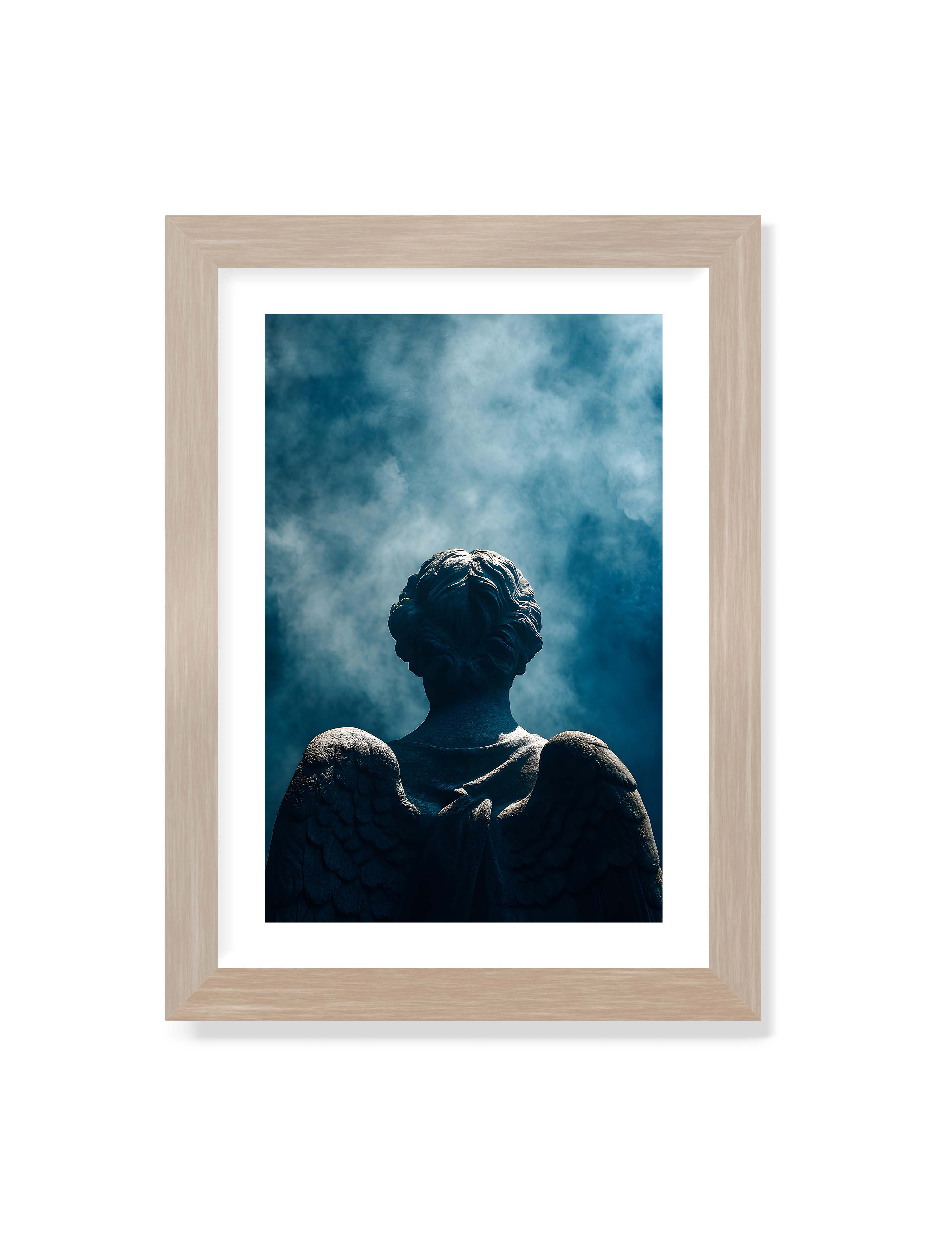 21x30 cm mit weißem Galerie-Rand im Eichenrahmen – Steinerne Engelsfigur von hinten mit ausgebreiteten Flügeln vor blauem, nebligem Himmel.